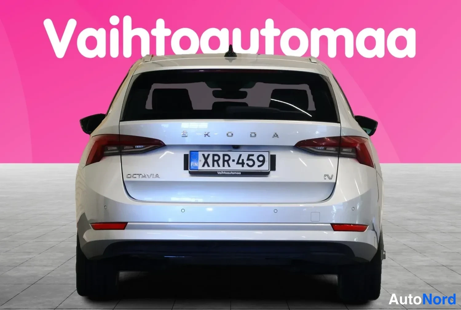 Takaa: Hopeanvärinen farmariauto suoraan takaa; SKODA-merkit, OCTAVIA-iV-teksti ja rekisterikilpi näkyvät takapöntössä.