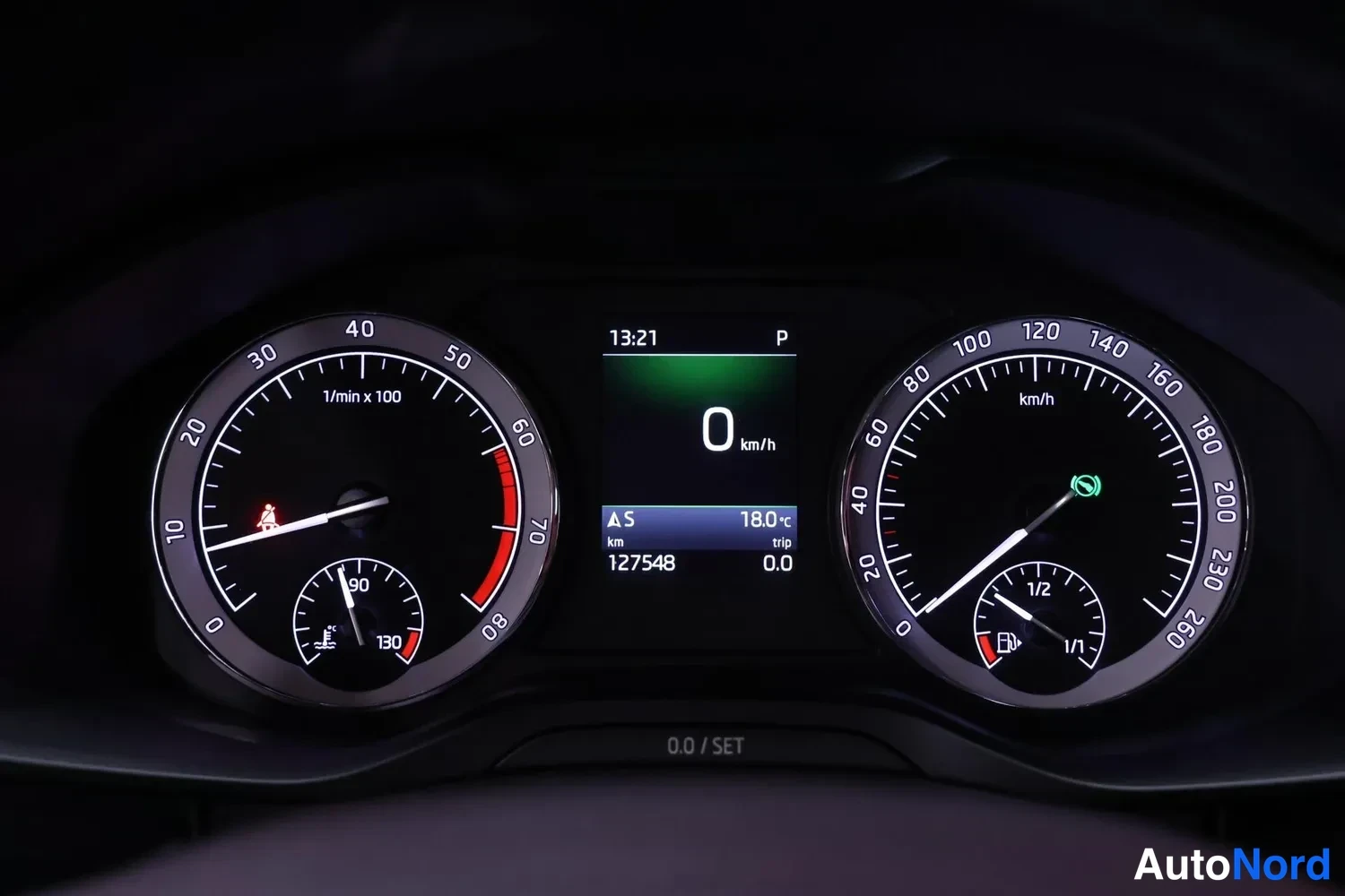 Muu: Mittariston näyttö jossa kokonaislukema 127548 km, vaihde P, nopeus 0 km/h ja kello 13:21.