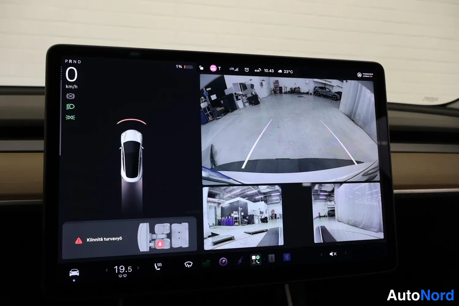 Muu: Tesla-näytön ruutu takakamera-näkymällä, ajotietoruudulla ja varoituksella 'Kliinitti turvavyö' sekä lukemalla '1%'.