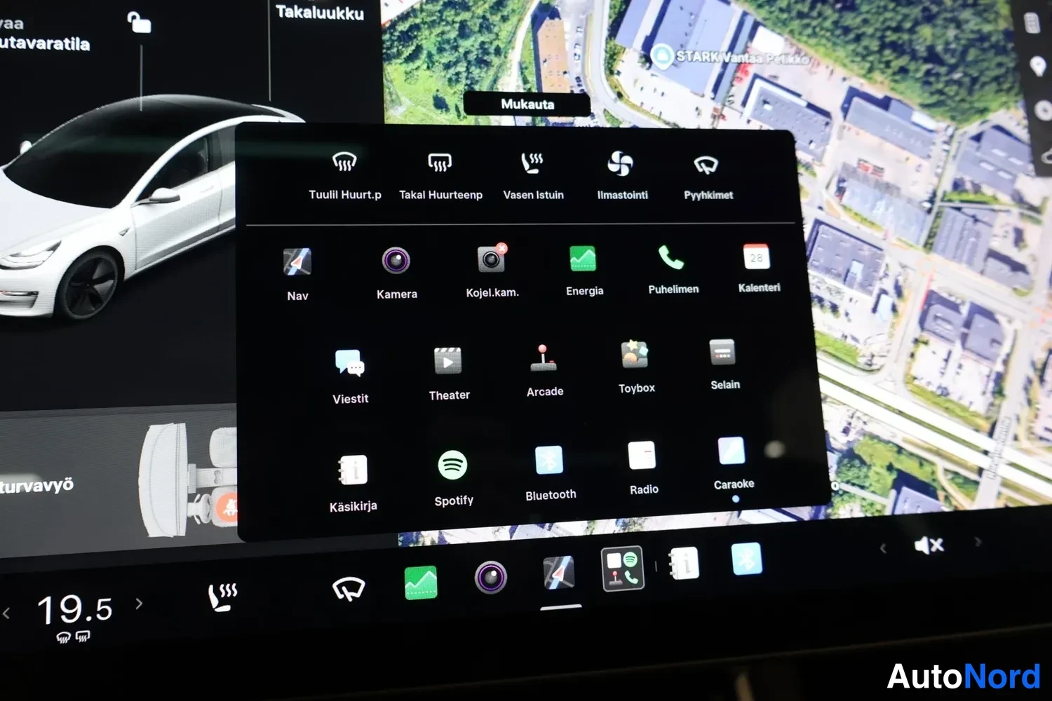 Muu: Tesla Model 3:n kosketusnäytön sovellusvalikko, jossa näkyvät muun muassa Nav, Kamera, Energia, Spotify, Bluetooth ja Radio -kuvakkeet.