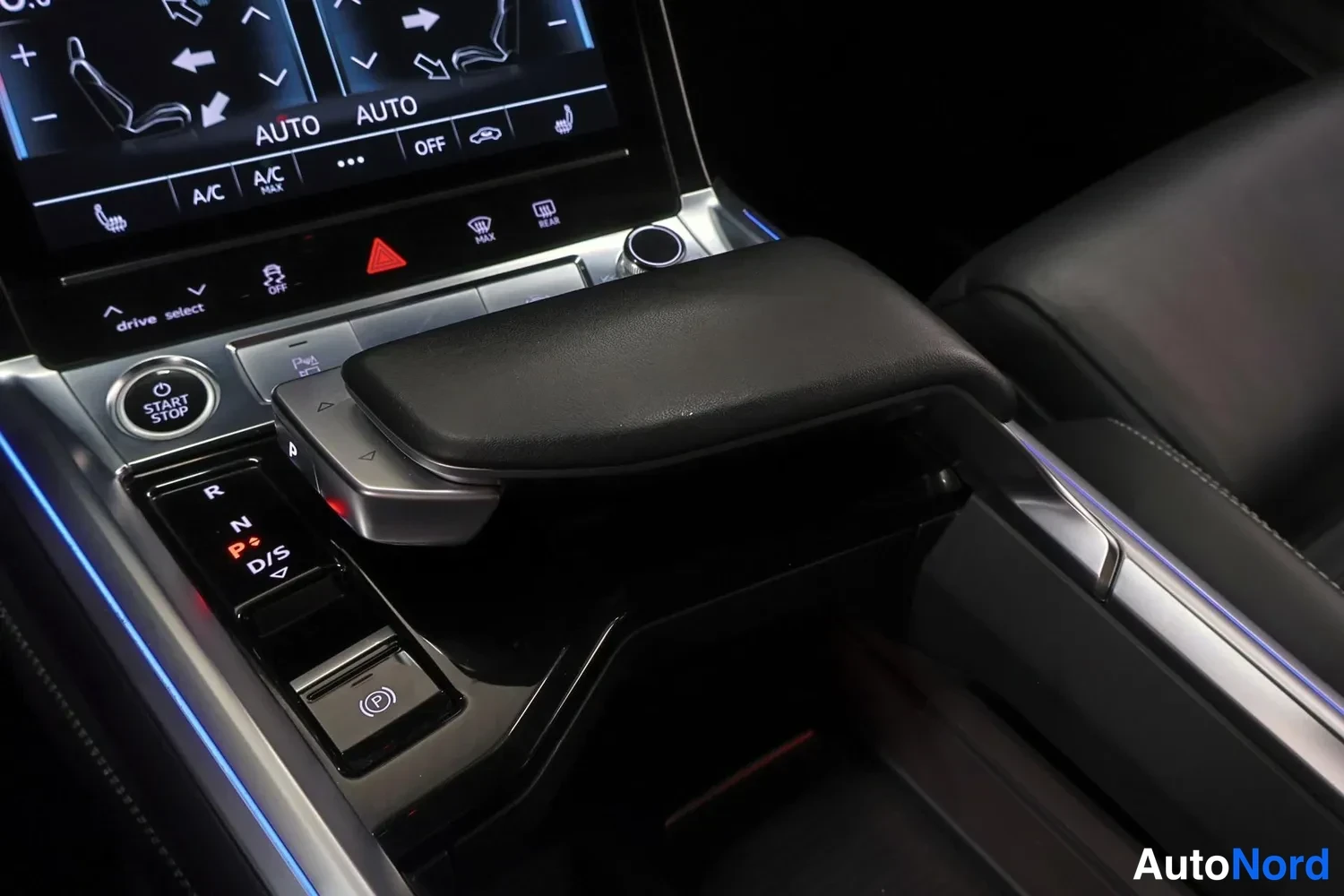 Muu: Audi e-tronin vaihtoValitsin ja keskihallsti: vaihtoehdot R, N, P ja D/S näkyvät valaistuna, sähköinen jarrukytkin (P) ja START STOP -painike, etälammenon kanne