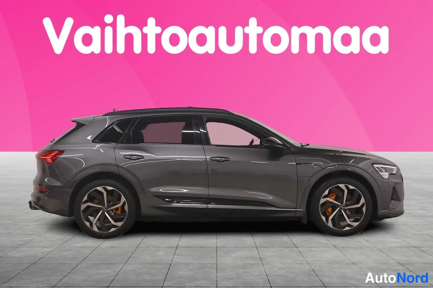 Etuviisto, nokka oikealle: Audi e-tron S sivulta oikealta etukolmannelta kuvattuna, harmaa koriväri ja kaksiväriset kevytmetallivanteet.