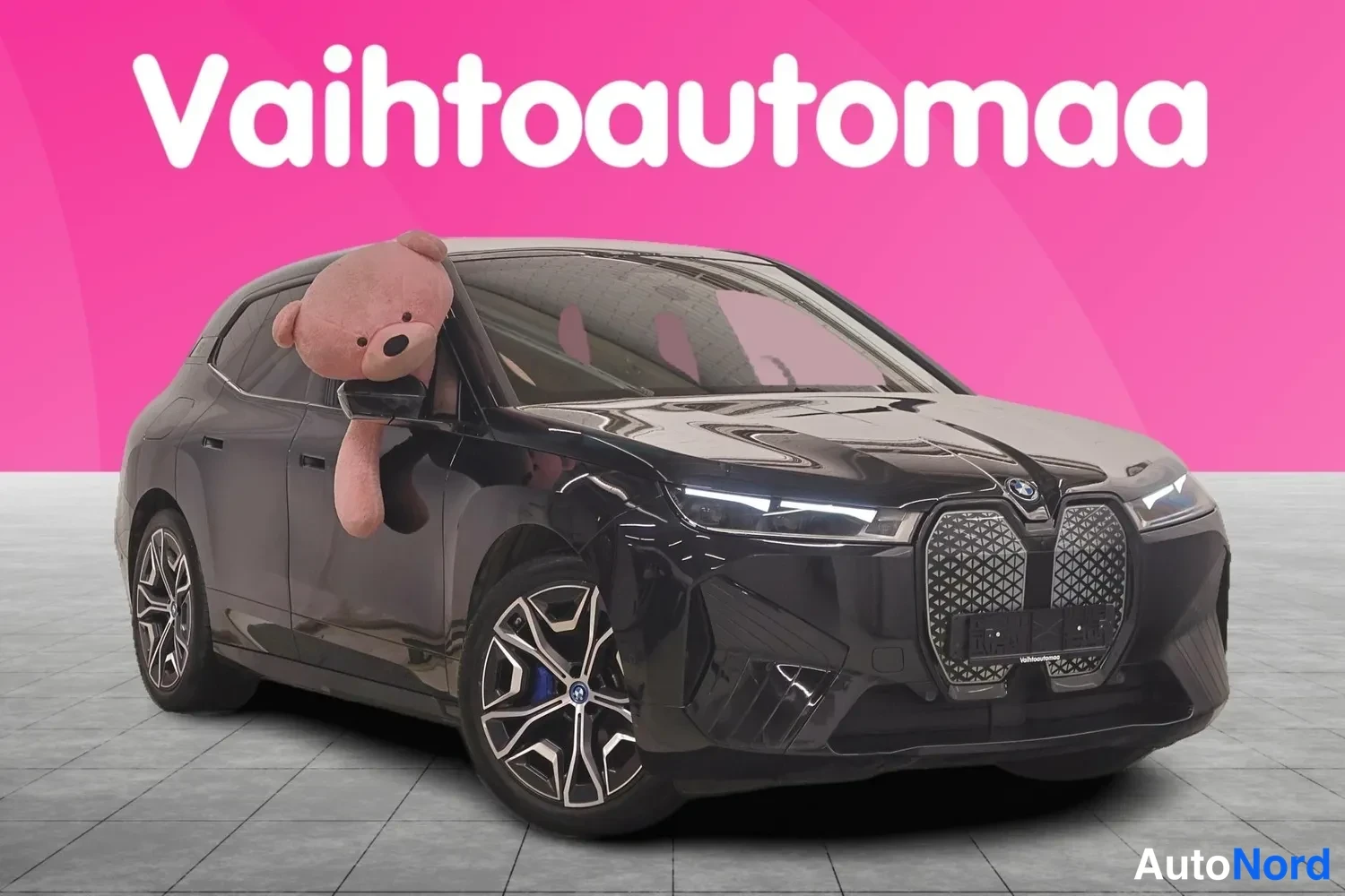 Etuviisto, nokka oikealle: Mustan BMW:n etukulmanäkymä oikealta, etusäleikkö ja ajovalot näkyvät, takapyörä vasemmalla.