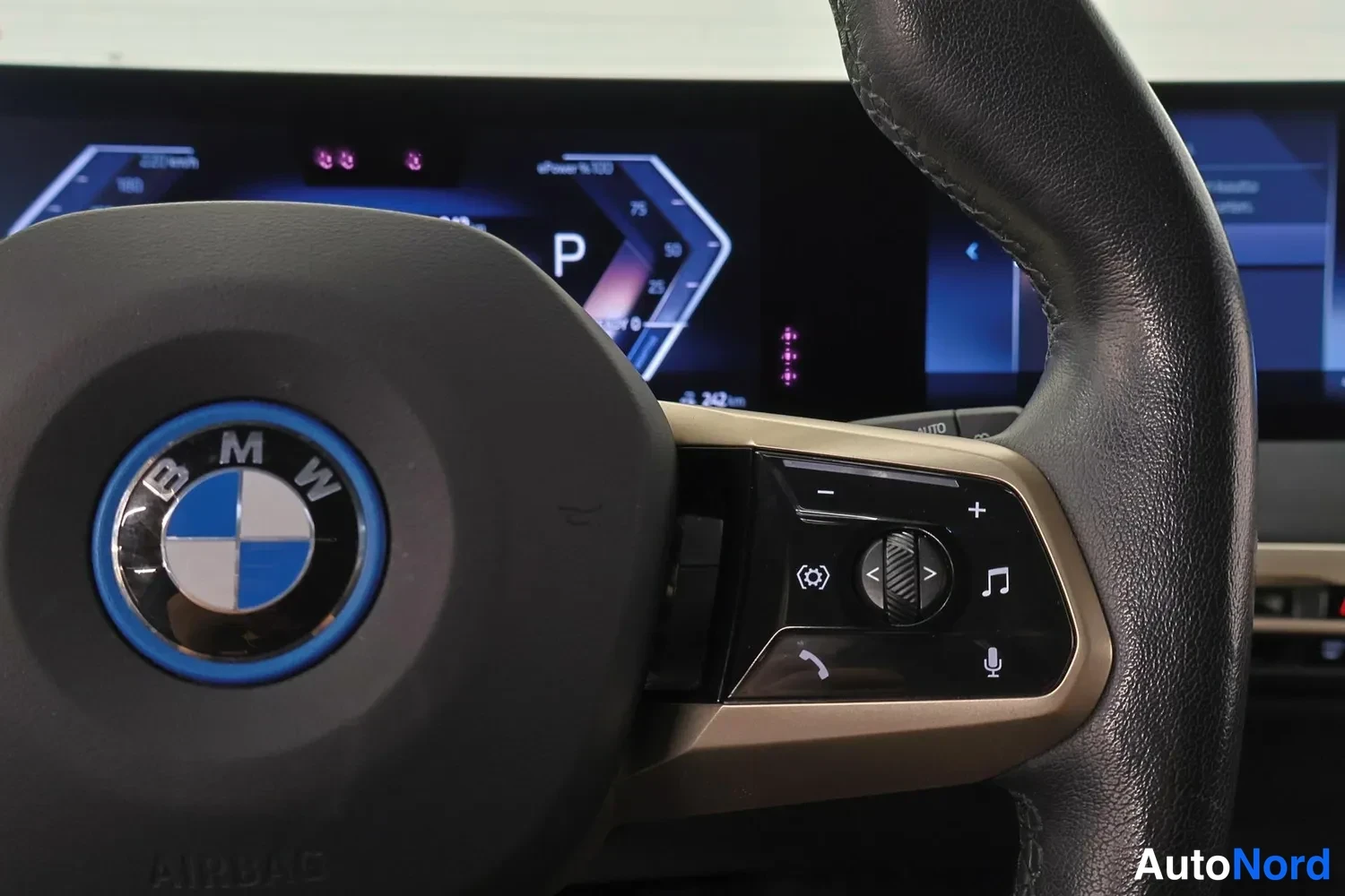 Muu: BMW-ohjauspyörä ja sen oikean puolen monitoimipainikkeet, taustalla digitaalinen mittaristo P-vaihteella.