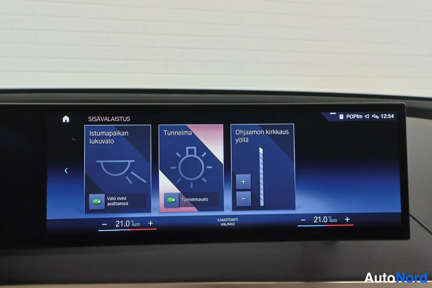 Yksityiskohta: Auton infotainment-näytön sisävalaistus-valikko vaihtoehdoilla istumapaikan lukuvalo, tunnelma ja ohjaamon kirkkaus yöllä.