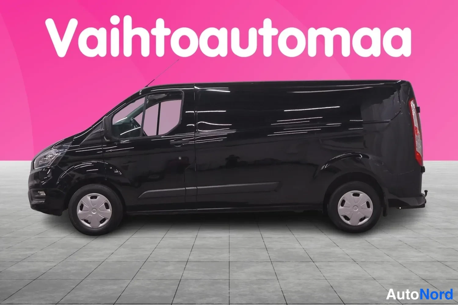 Etuviisto, nokka vasemmalle: Ford Transit Custom -pakettiauto sivulta mustana