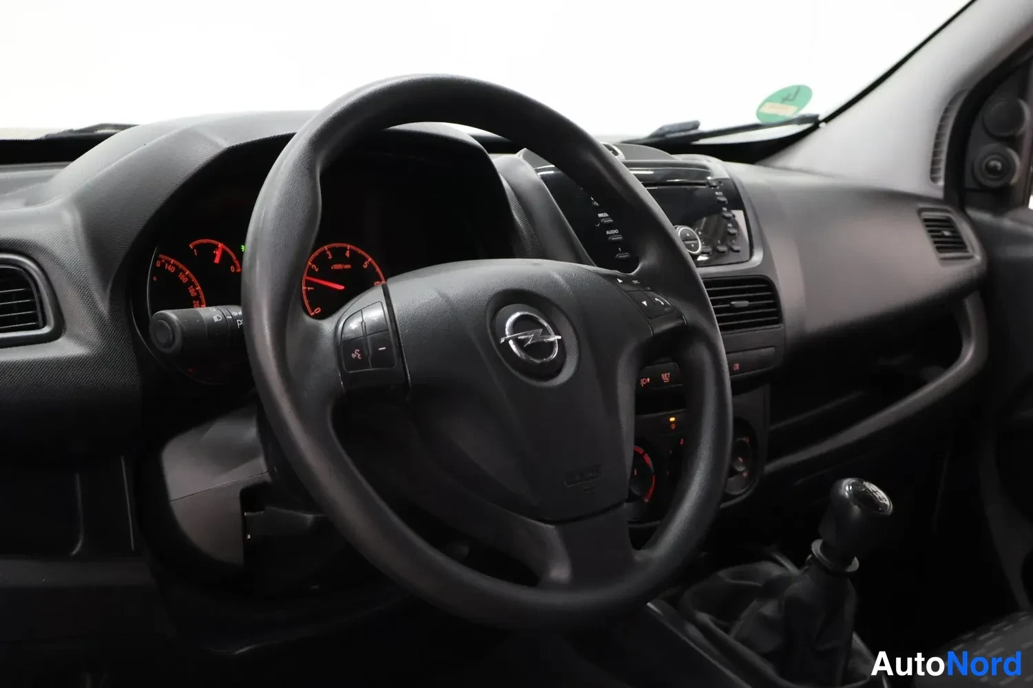 Edestä: Opel-ohjauspyörä ja mittarit, manuaalivaihto ja radio kojelaudassa