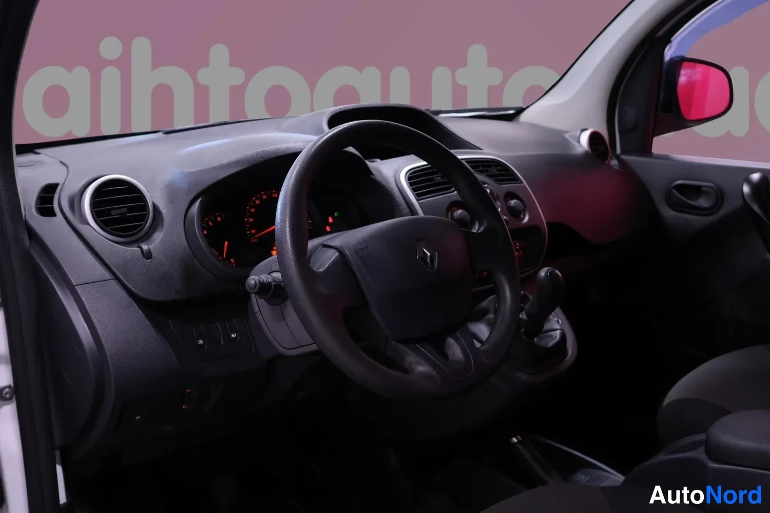 Muu: Ohjaamo vasemmalta kuvattuna: Renault-logolla varustettu ohjauspyörä, analogiset mittarit, ilmastointiritilät, manuaalivaihteen vipu ja käsijarru.