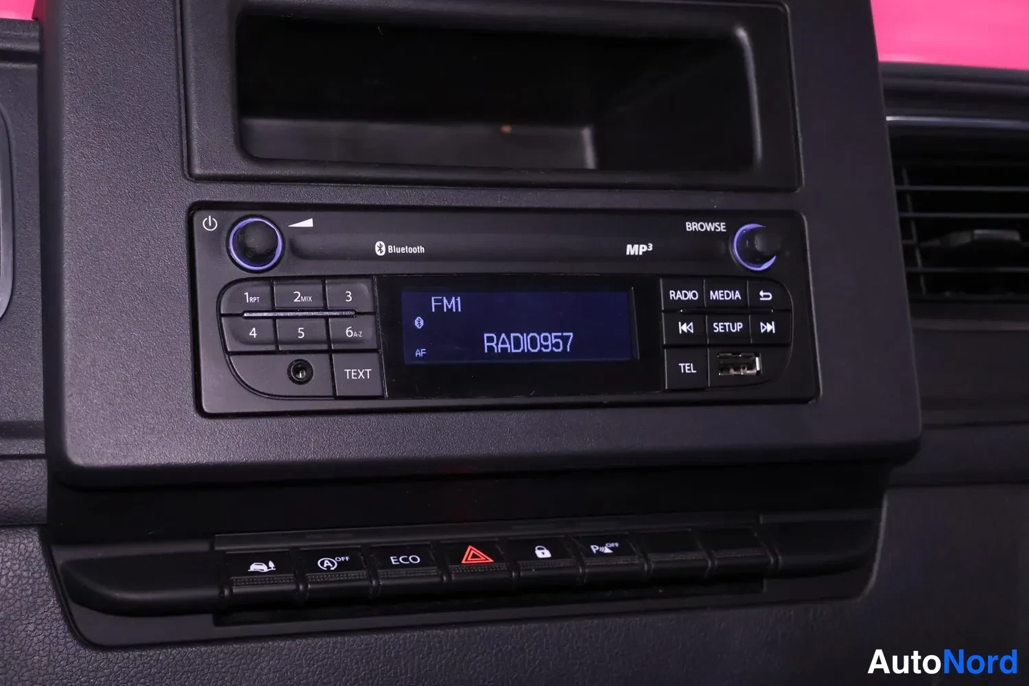 Muu: Kojetaulun radio näyttää FM1 RADIO0957, paneelissa Bluetooth-, MP3- ja USB-merkit sekä alla olevat painikkeet ECO, varoitusvalo ja lukitus.