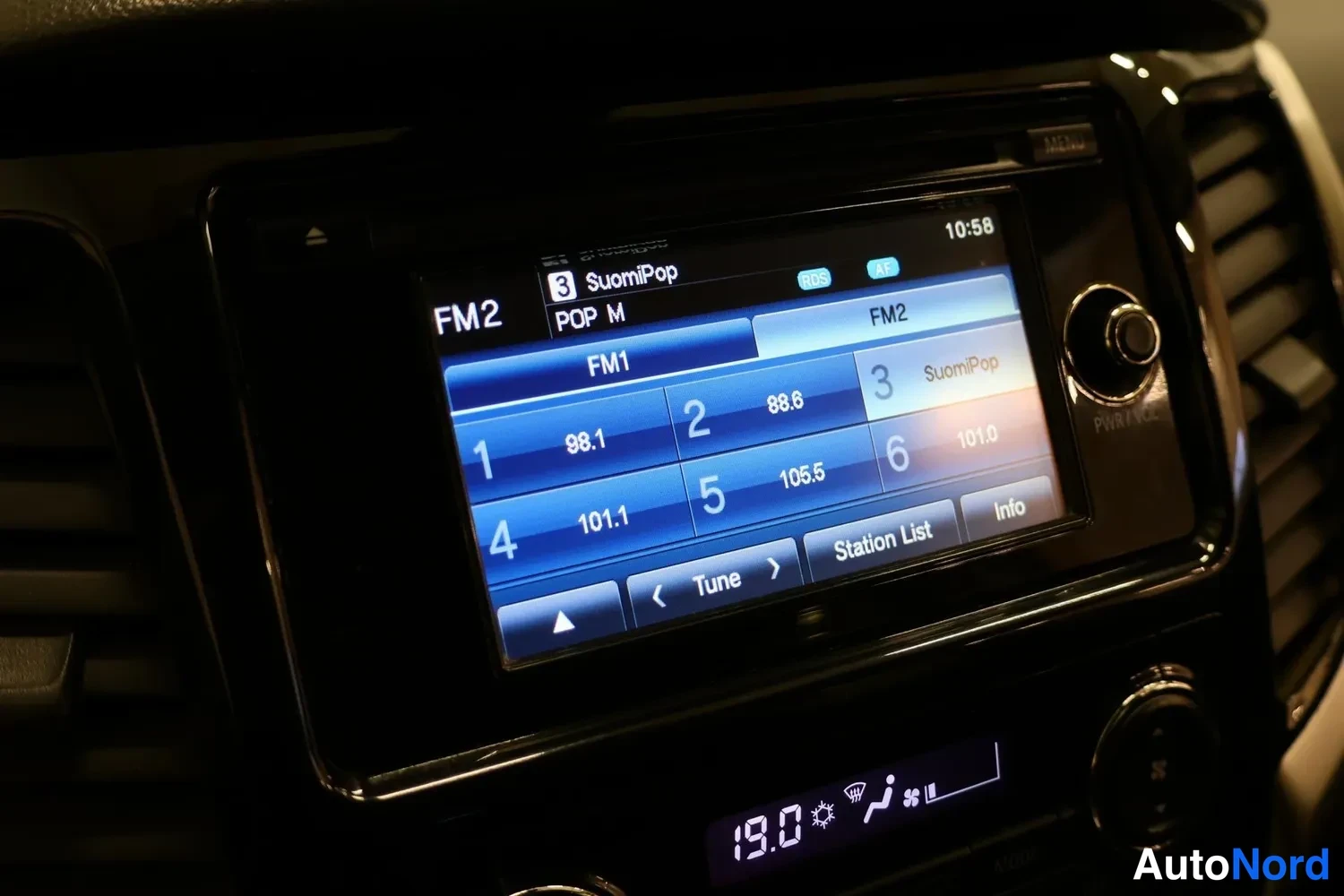 Muu: Viihdejärjestelmän näyttö FM2-radiokanavalistalla, teksti 'SuomiPop' ja kellonaika 10:58.