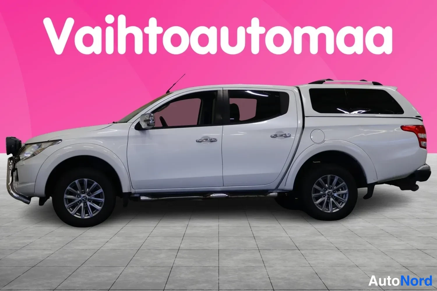 Sivulta: Mitsubishi L200 Double Cab sivusta valkoisena, korin yllä musta kovakuormatila.
