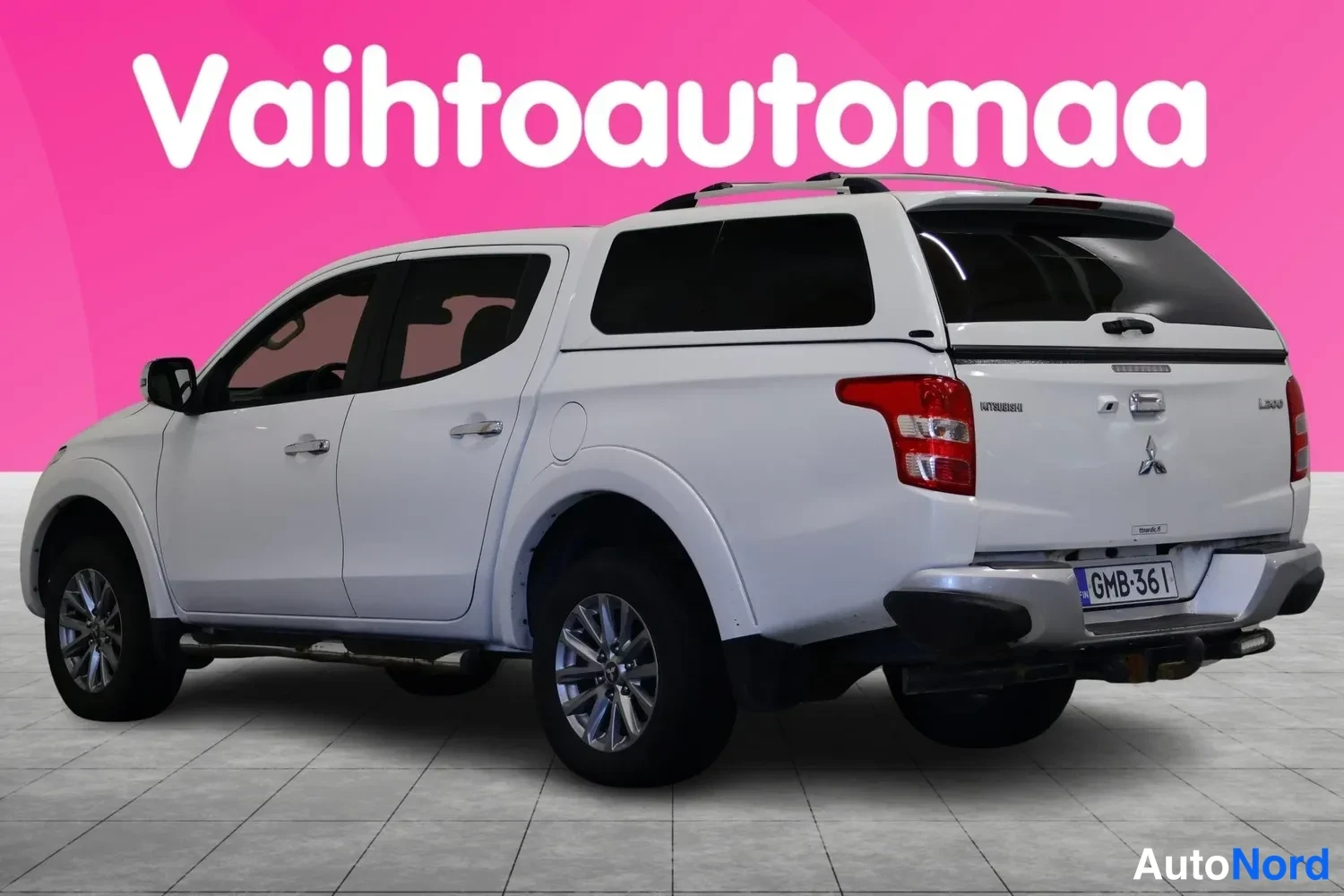 Takaviisto: Mitsubishi L200 takaviistosta valkoisena, takana L200-merkintä ja rekisteritunnus.