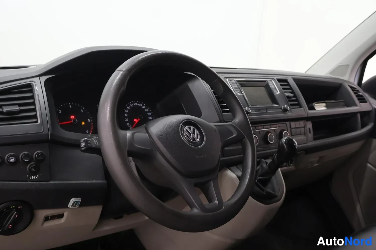 Muu: Volkswagen-merkitty ohjauspyörä, mittaristo ja keskikonsoli radio-näytöllä ja manuaalivaihteen keilalla.