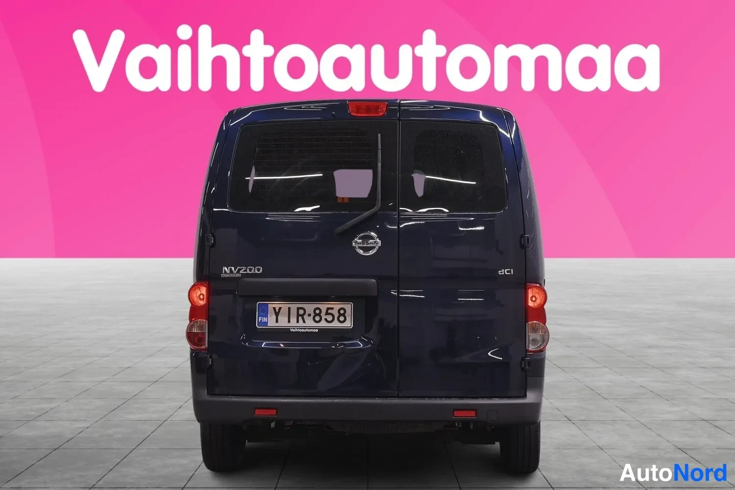 Takaa: Tummansinisen Nissan NV200 -pakettiauton peräkuvat suoraan takaa, rekisterikilpi, NV200 ja dci-merkinnät.