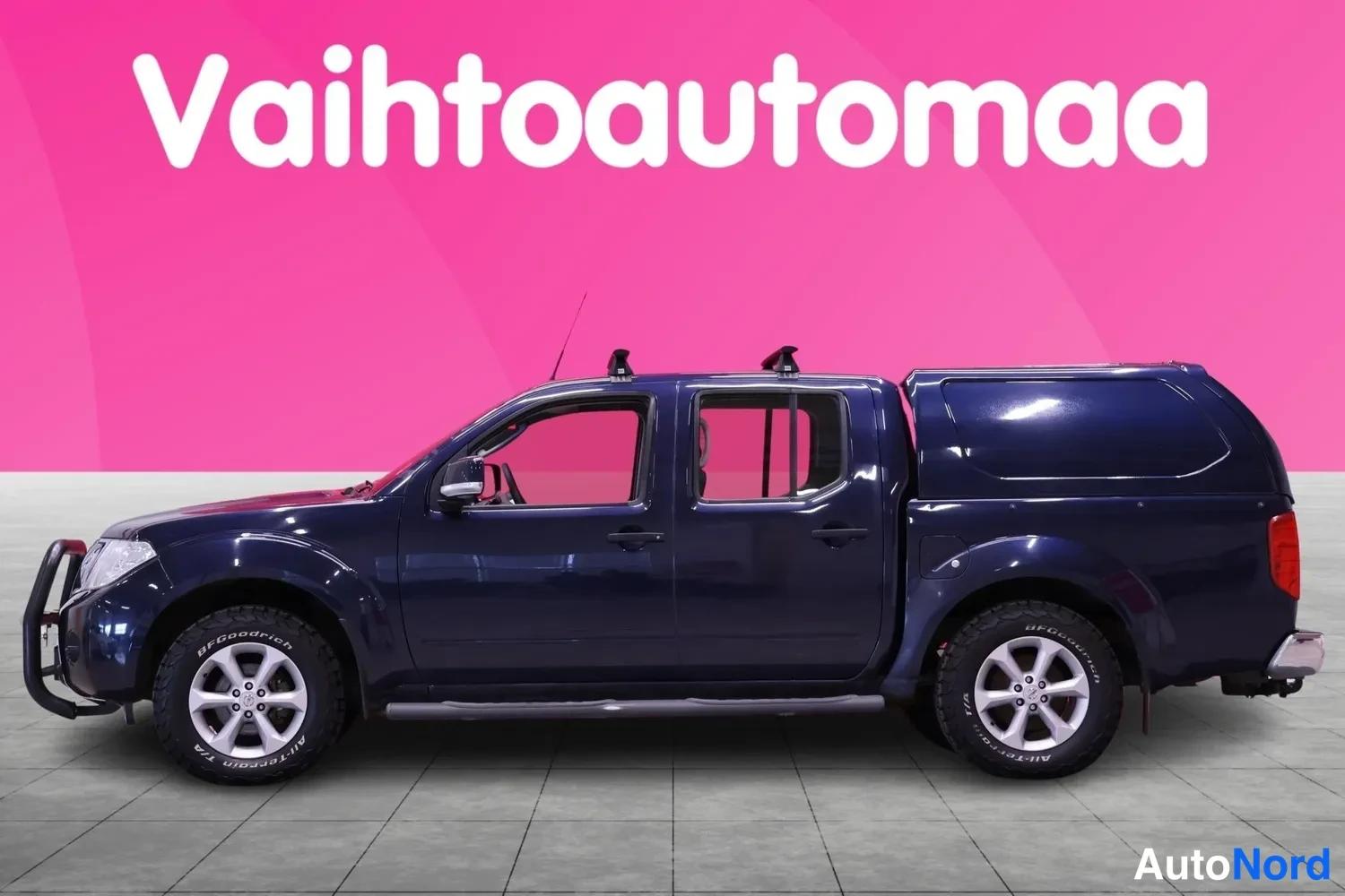 Sivulta: Nissan Navara sivusuunnasta vasemmalta; tummansininen koripelti, neljä ovea ja kattoteline.