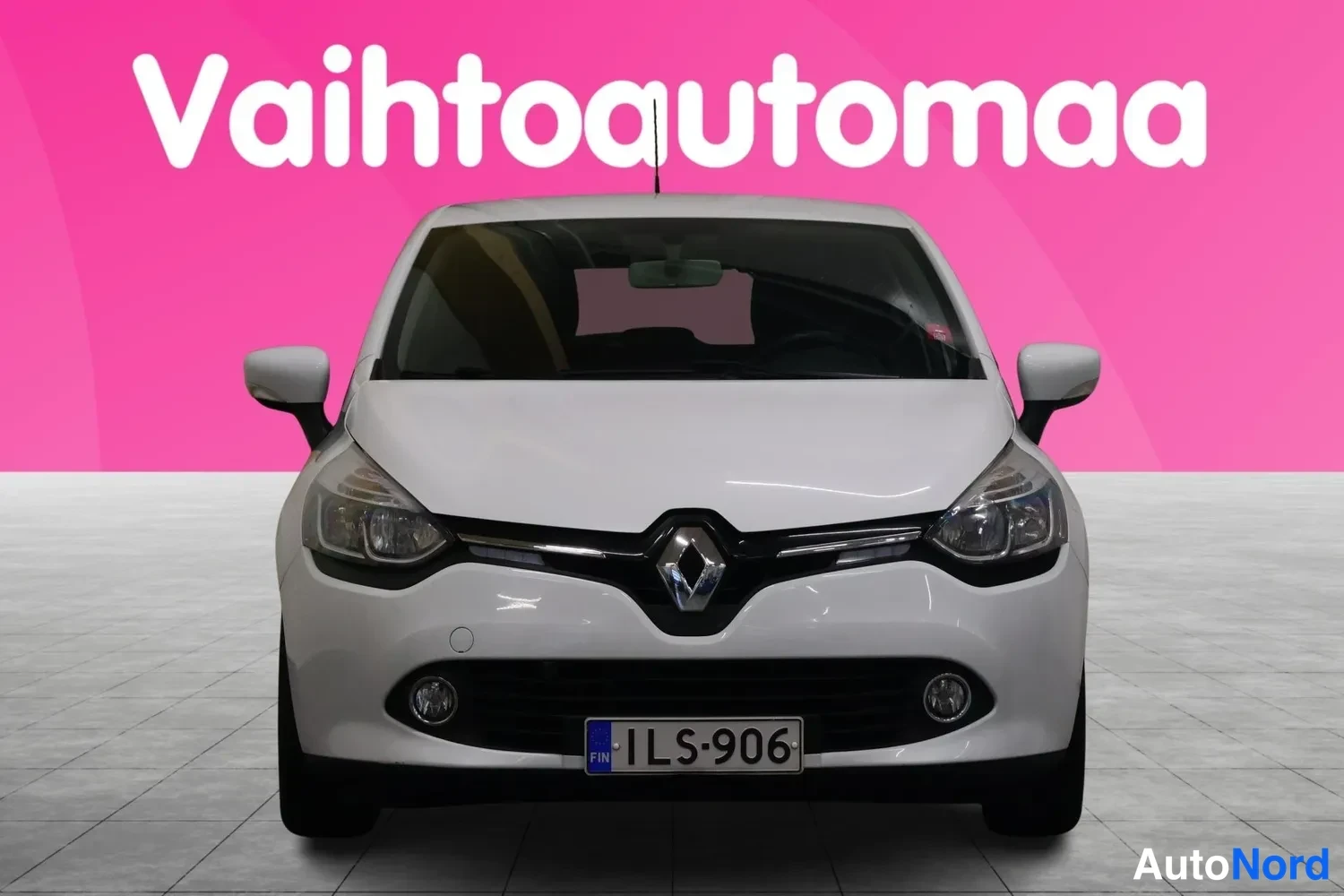 Edestä: Valkoinen Renault Clio suoraan edestä kuvattuna, rekisteritunnus.