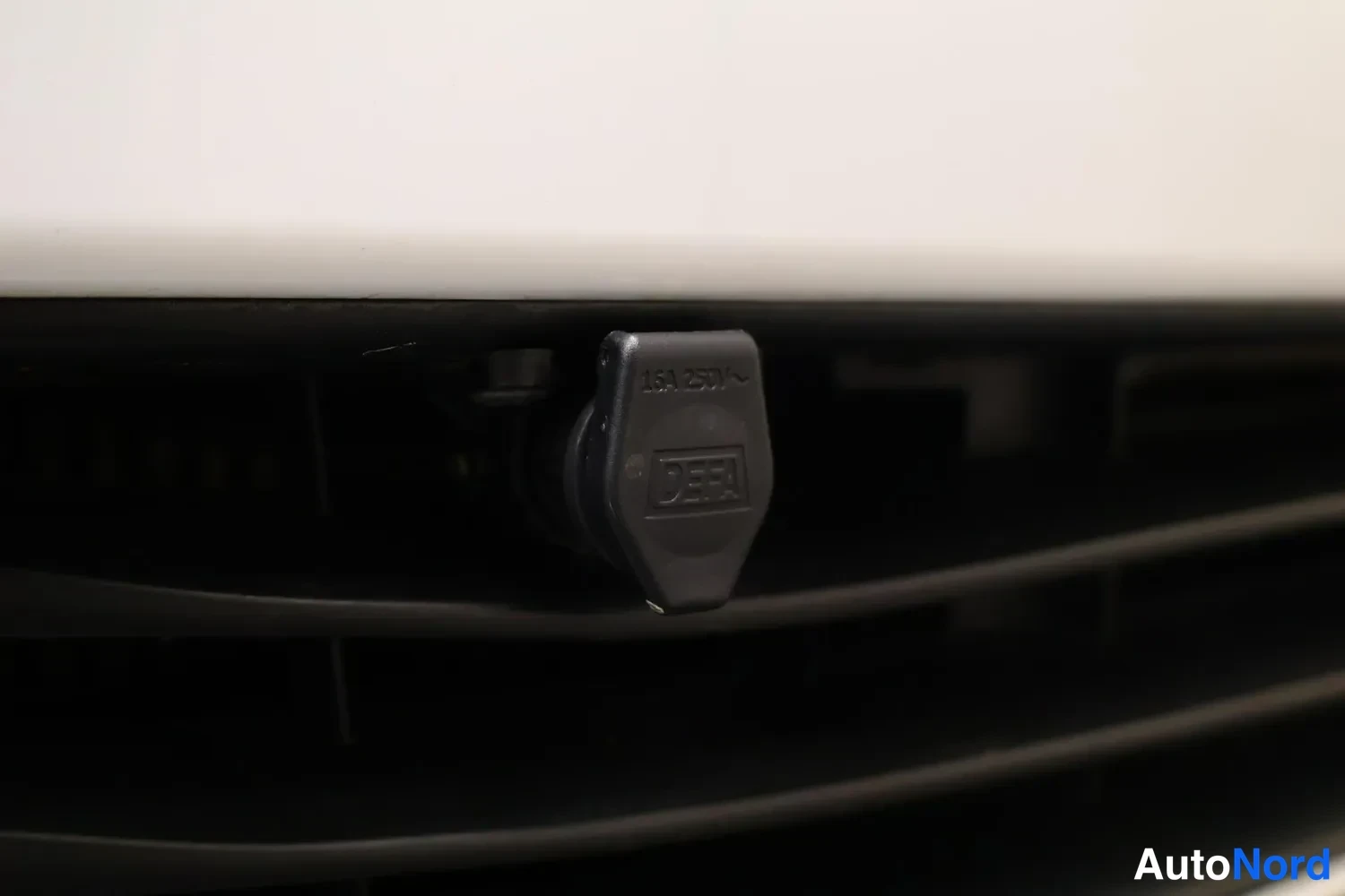 Yksityiskohta: DEFA-lisälaitteistoliitin, merkintä 16A 250V, autossa.