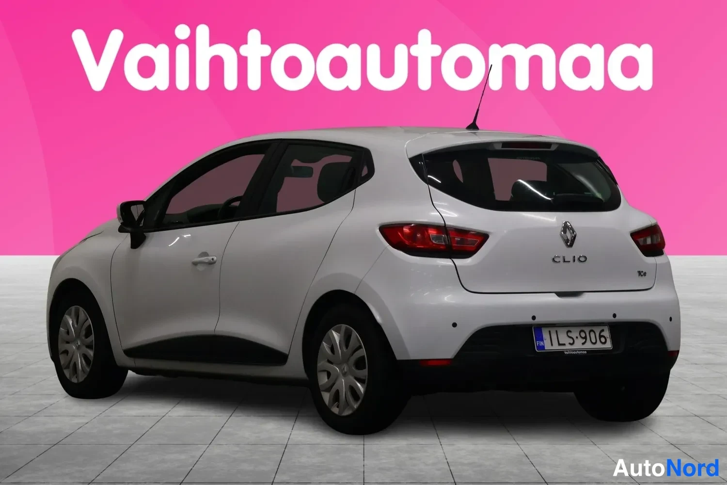 Takaviisto: Valkoisen Renault Clin takakulmanäyttö: rekisterikilpi ja CLIO-tunus näkyvät.