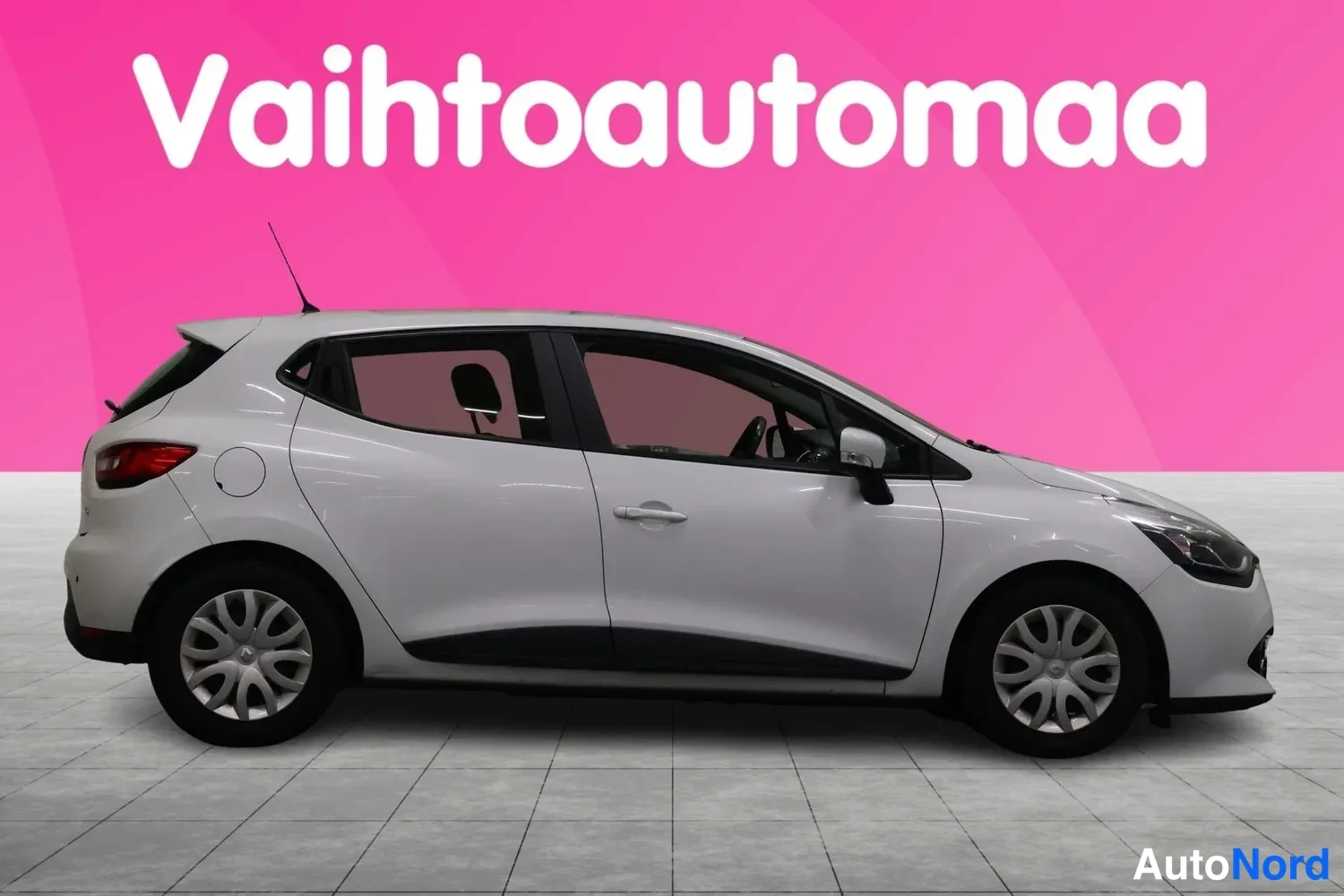 Etuviisto, nokka oikealle: Valkoisen Renault Cliohatchbackin etukulma oikealta, auton keulan ja oikean sivun näkyessä.