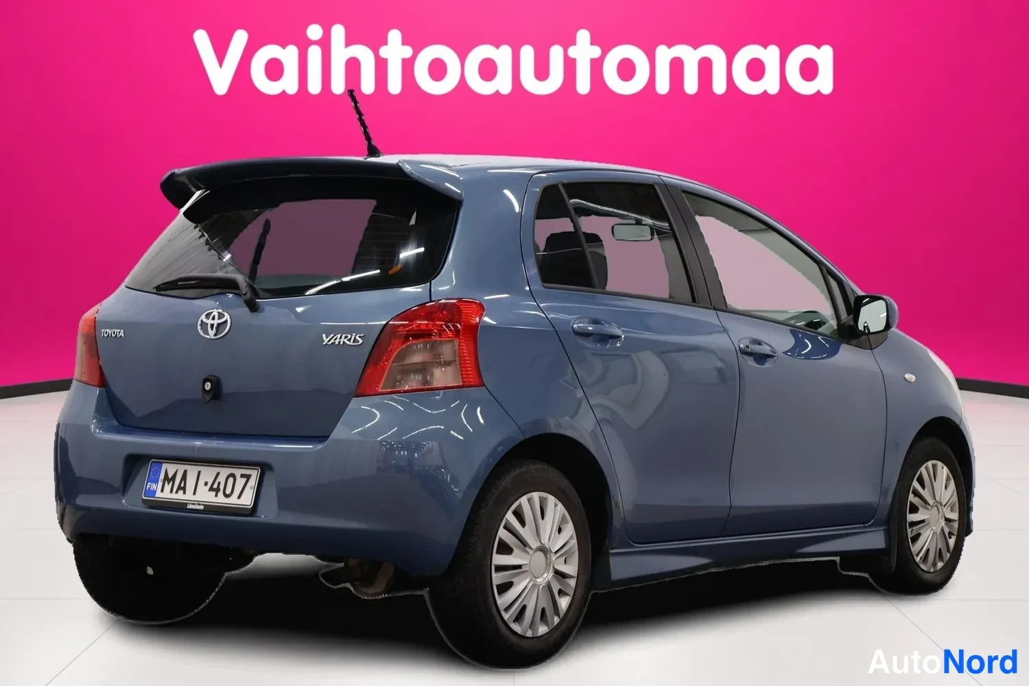 Takaviisto: Sininen Toyota Yaris -viistoperä takaa vasemmalta oikealle kuvattuna, rekisteritunnus