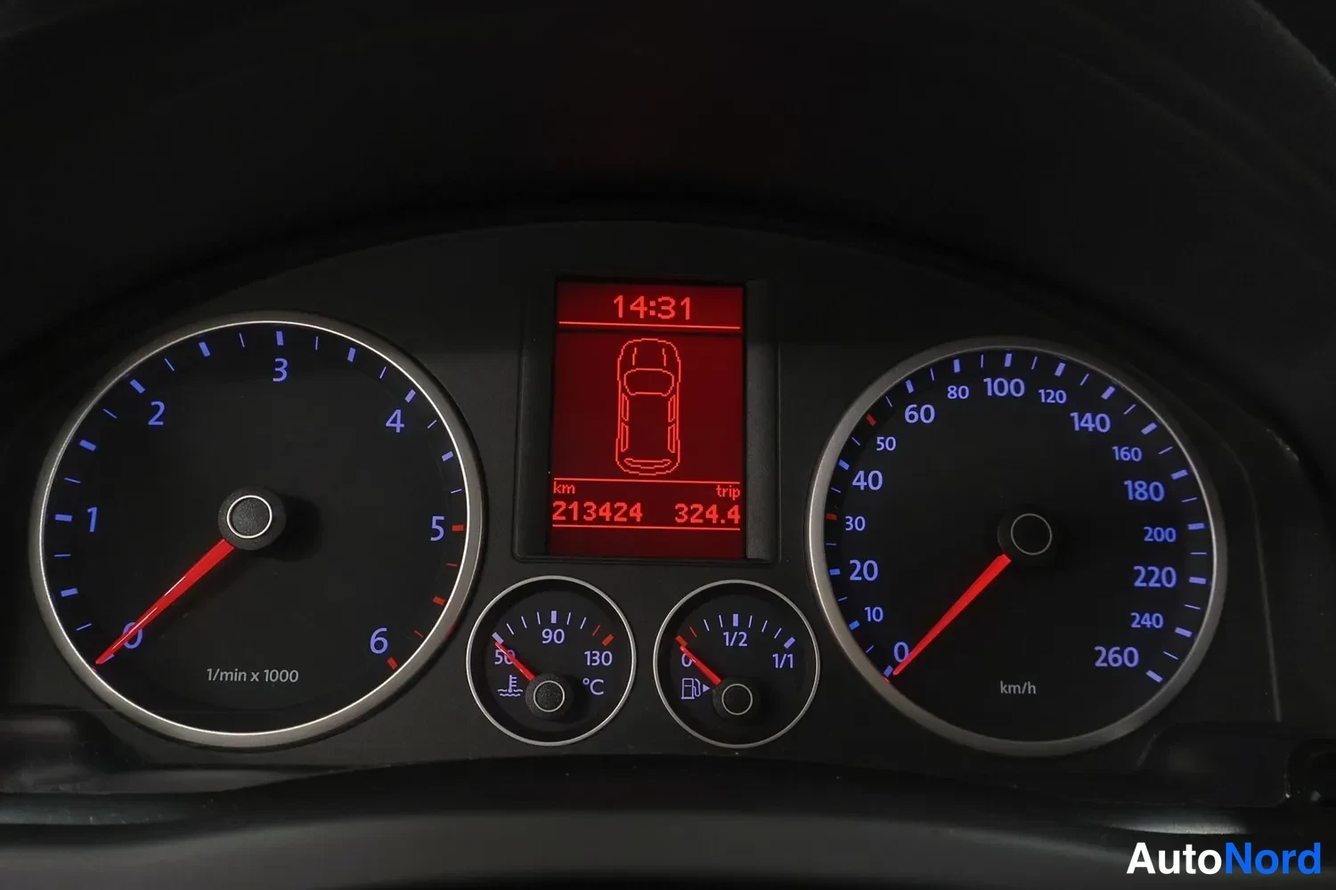Muu: Kojelaudan mittaristo: punainen näyttö näyttää kellon 14:31, matkamittarin 213424 km ja tripin 324,4; kierroslukumittari ja nopeusmittari punaisilla neuloilla.