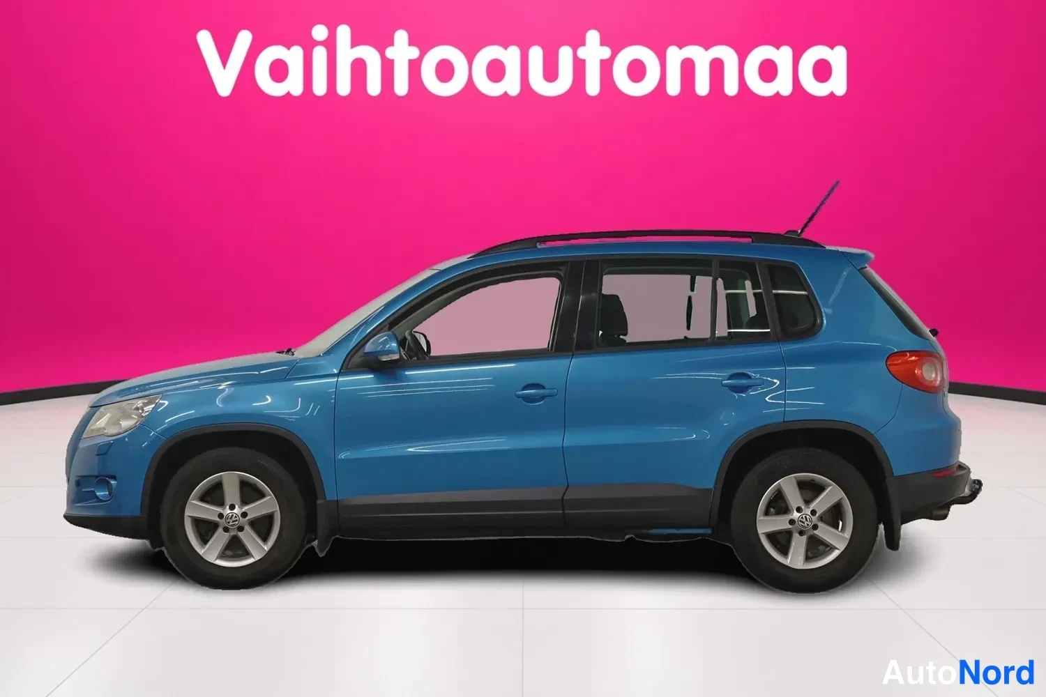 Sivulta: Sininen Volkswagen Tiguan kyljestä oikealta katsottuna studioympäristössä.