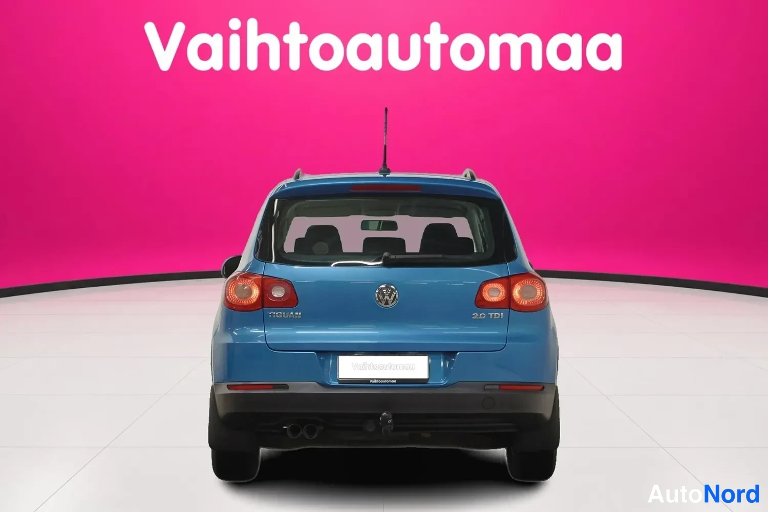Takaa: Sininen Volkswagen Tiguan suoraan takaa, t Merkinnät TIGUAN ja 2.0 TDI näkyvät peräluukussa.