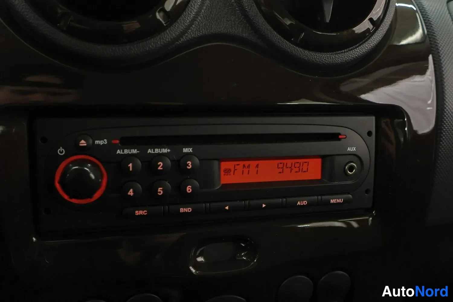 Muu: Auton radiopaneeli: äänenvoimakkuuspainike, mp3-merkintä, numeronäppäimet 1–6 ja näytöllä FM1 94.90; AUX- ja MENU-painikkeet.