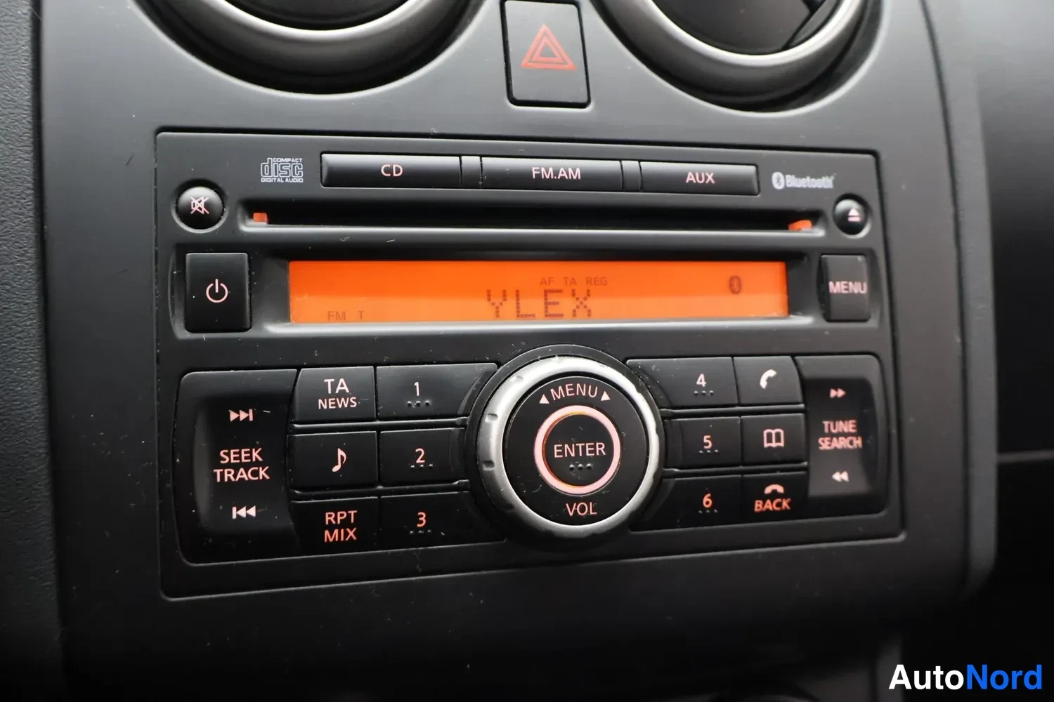 Yksityiskohta: Radion ja CD-soittimen paneeli, näytössä teksti YLEX, napit CD, FM.AM, AUX, Bluetooth, MENU, ENTER ja VOL.