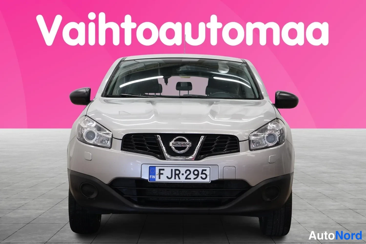 Edestä: Hopeanharmaa Nissan Qashqai suoraan edestäpäin kuvattuna, rekisteritunnus F JR-295.