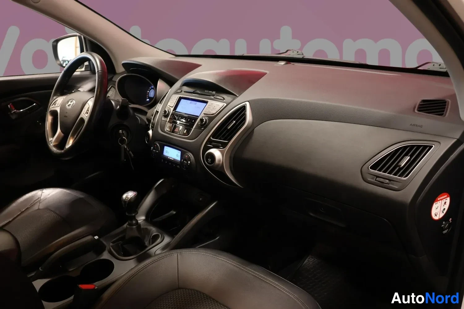 Muu: Hyundai ix35:n matkustamo: ohjauspyörä, keskikonsolin näyttö, manuaalivaihtoehdin vaihtokeksi ja tummat verhoilut.