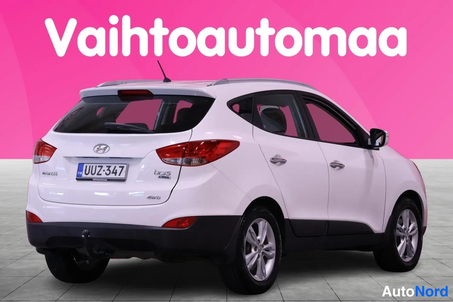 Takaviisto: Valkoinen Hyundai ix35 taka-kolmasosakuva vasemmasta sivusta, takamoottorin kansi auki, lyhtysekoitus CRDi-tekstillä.