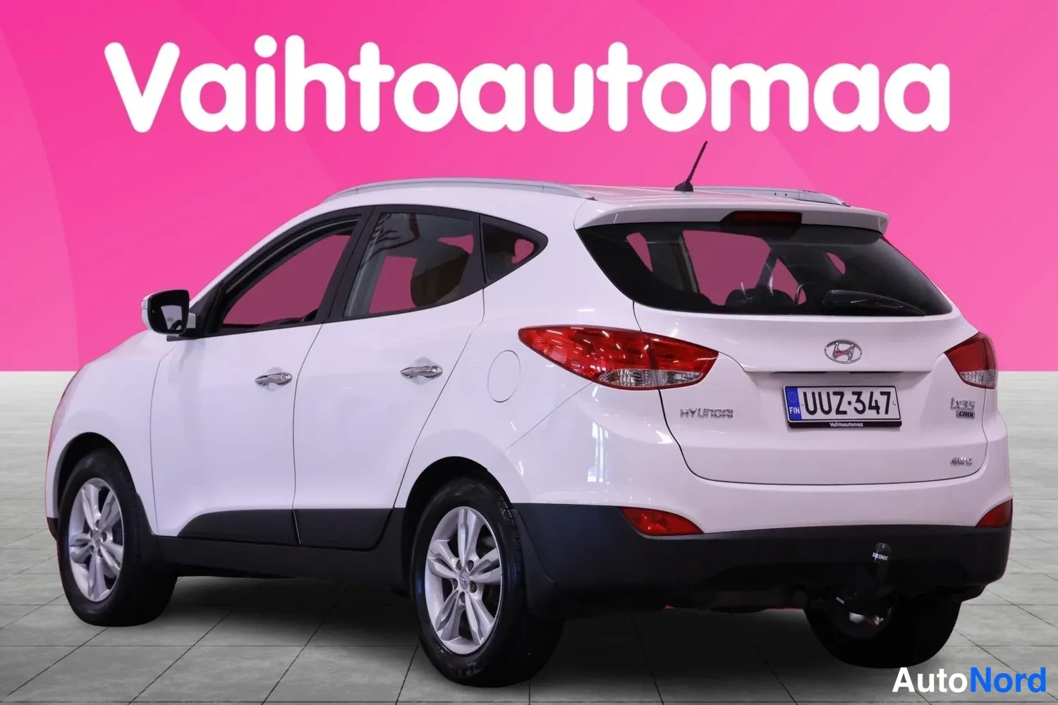 Takaviisto: Valkoinen Hyundain kattopaikkamallinen auto, kuvaajaksi oikea takapuoli. Takavalot, takaluukku, rekisterinumero ja peräkontin vetoaukko näkyvät.