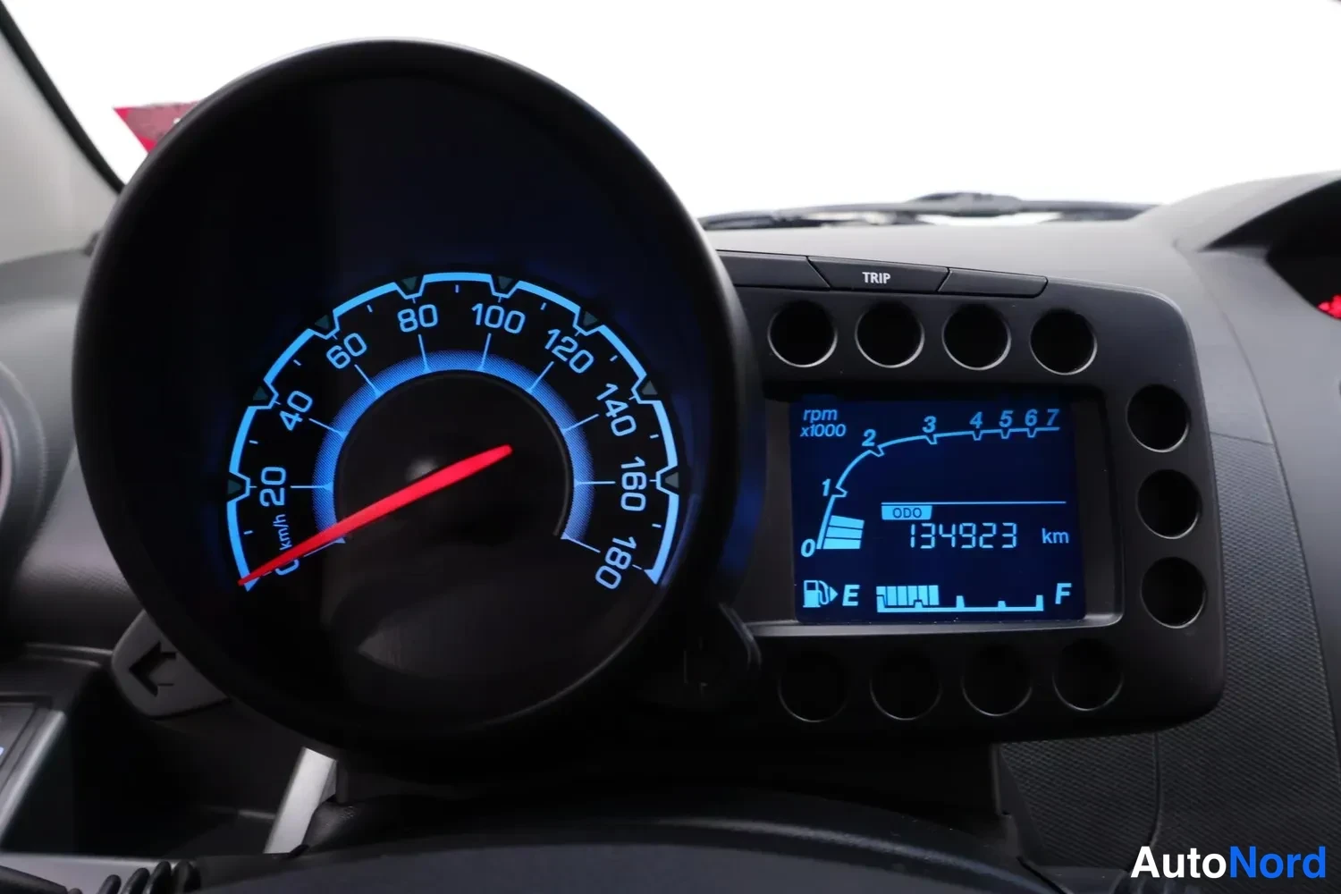 Muu: Tunturimittarin lähikuva, nopeusmittari 0–180 km/h ja odometerissa 134923 km.