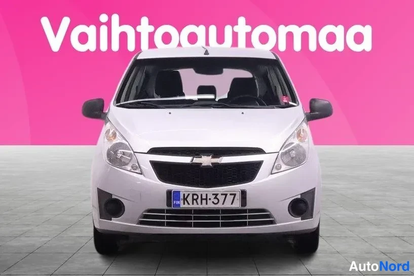 Edestä: Hopeanvärinen Chevrolet Spark suoraan edestä, rekisterikilpi.