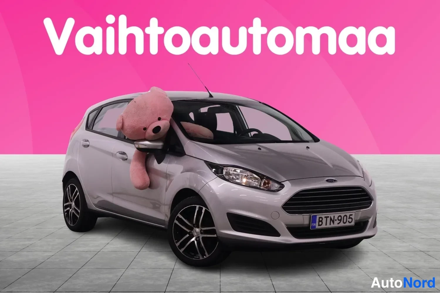 Etuviisto, nokka oikealle: Hopeanharmaa Ford Fiesta etuosa kolmivartalokuvassa, rekisteritunnus.