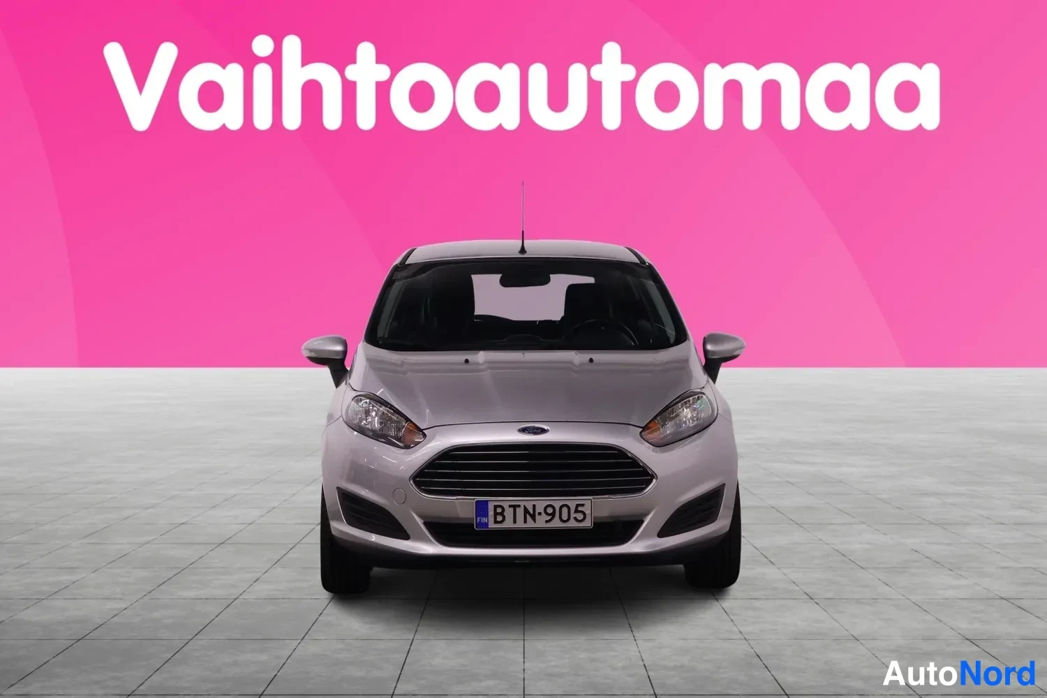Edestä: Hopeanharmaa Ford Fiesta suoraan edestä kuvattuna, rekisteritunnus.