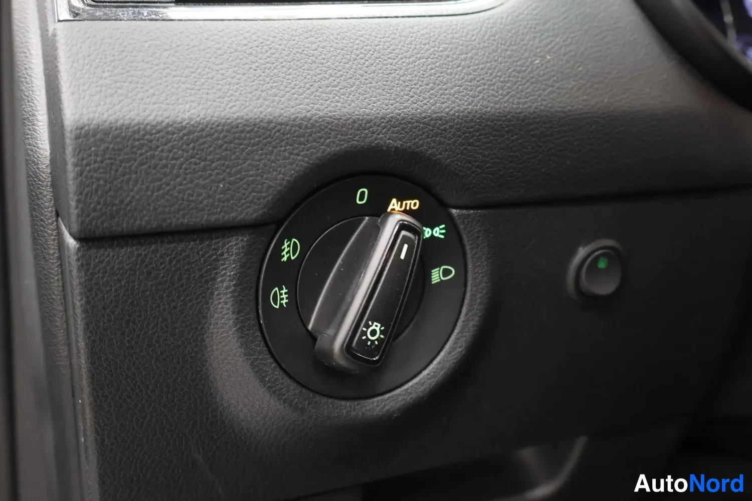 Muu: Autovalonsäädin kojelaudassa, jossa Auto-asento ja sumuvalo-napit.