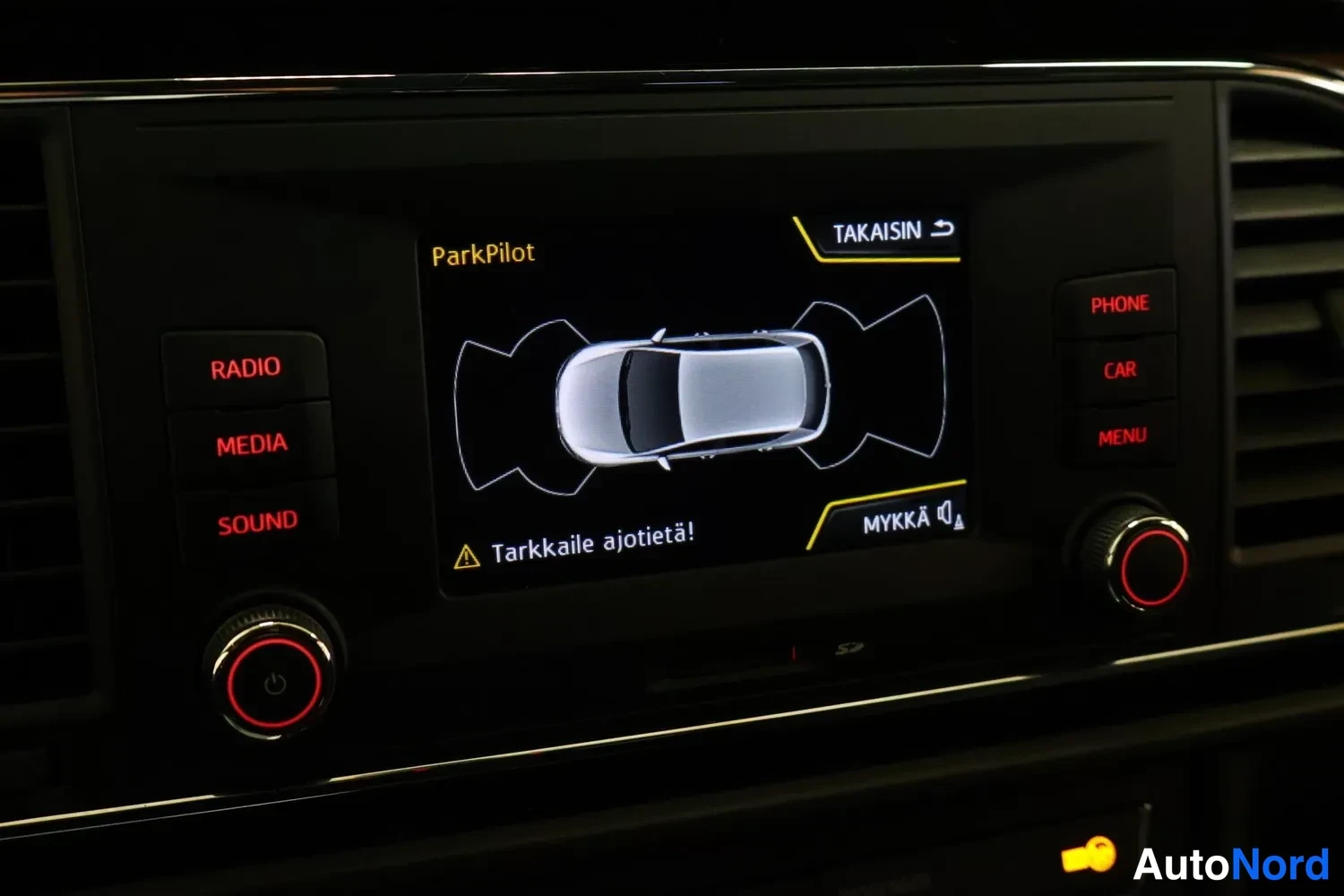 Muu: Infotainment-näyttö näyttää ParkPilot-tutkafontWeight-kuvan tekstillä 'Tarkkaile ajotietä!'