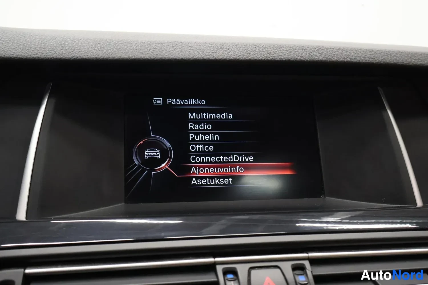 Muu: Auton infotainment-näyttö päävalikossa, jossa vaihtoehtoina Multimedia, Radio, Puhelin, Office, ConnectedDrive, Ajoneuvoinfo ja Asetukset.