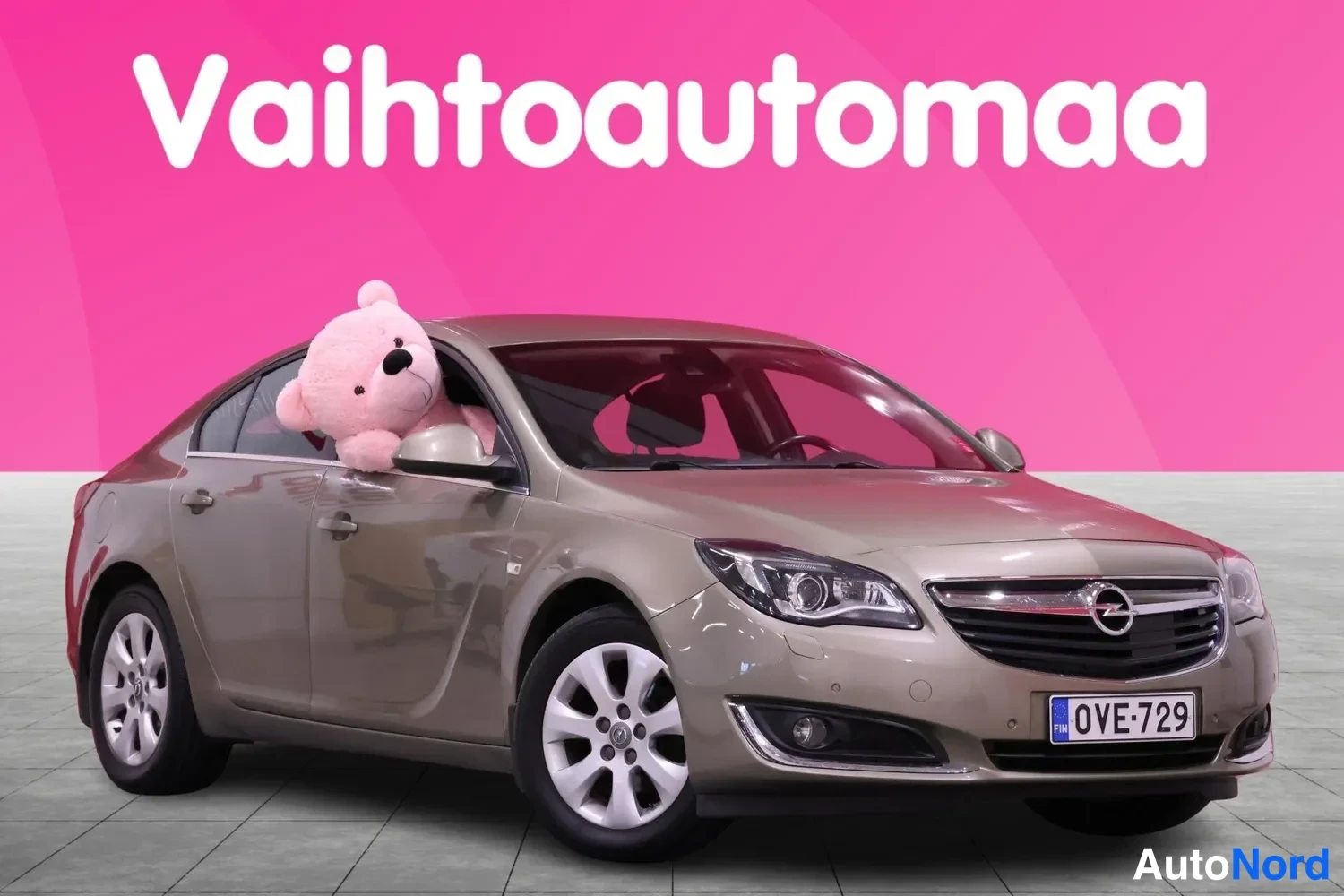 Etuviisto, nokka oikealle: Ruskeanharmaa sedan-auton etukulma vasemmalta, rekisteritunnus.