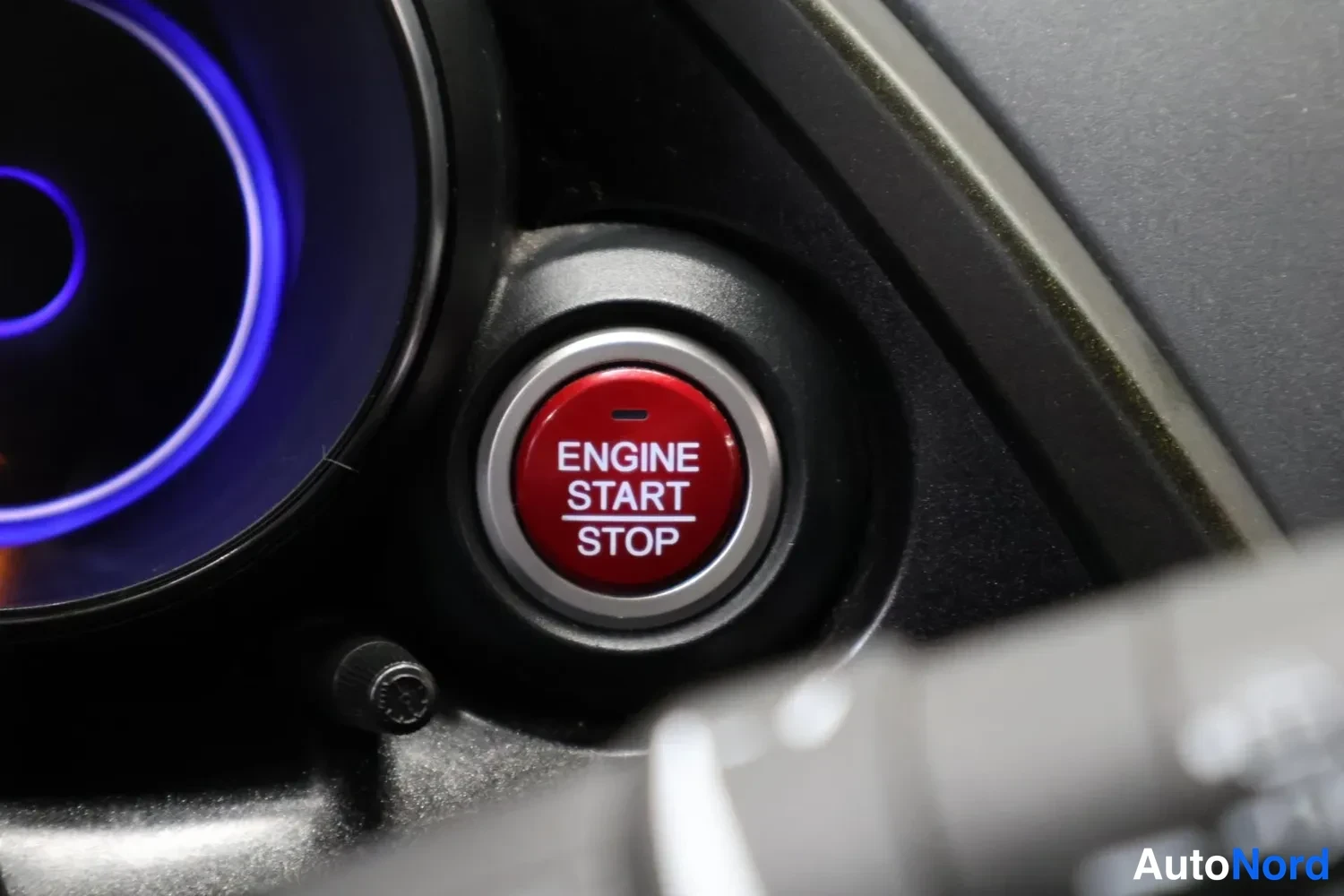 Muu: Punainen ENGINE START STOP -käynnistysnappi kojetaulussa sinisen merkkivalon lähellä.
