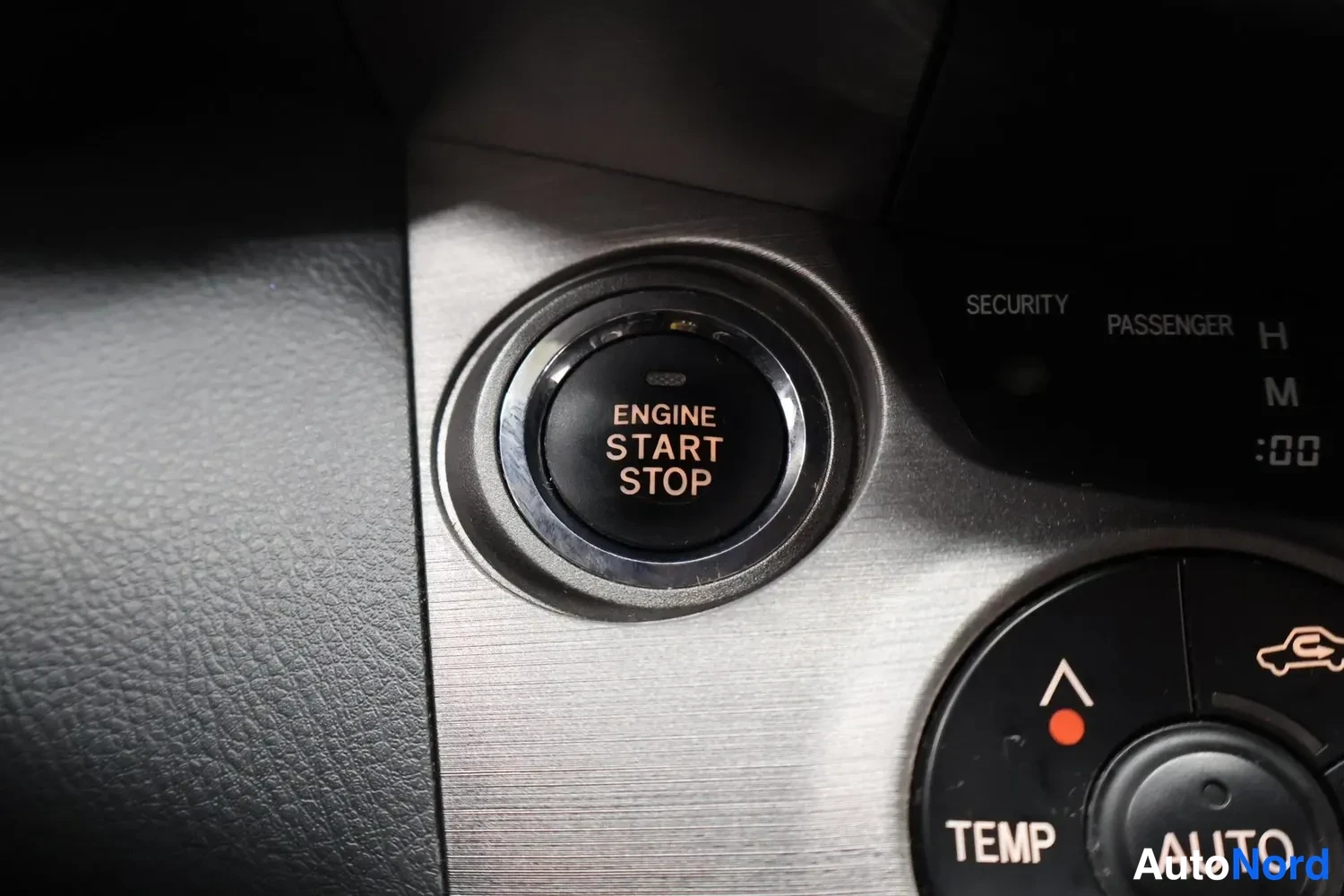 Yksityiskohta: Start/stop-käynnistyspainike ENGINE START STOP ja ilmastoinnin TEMP- ja AUTO-napit.