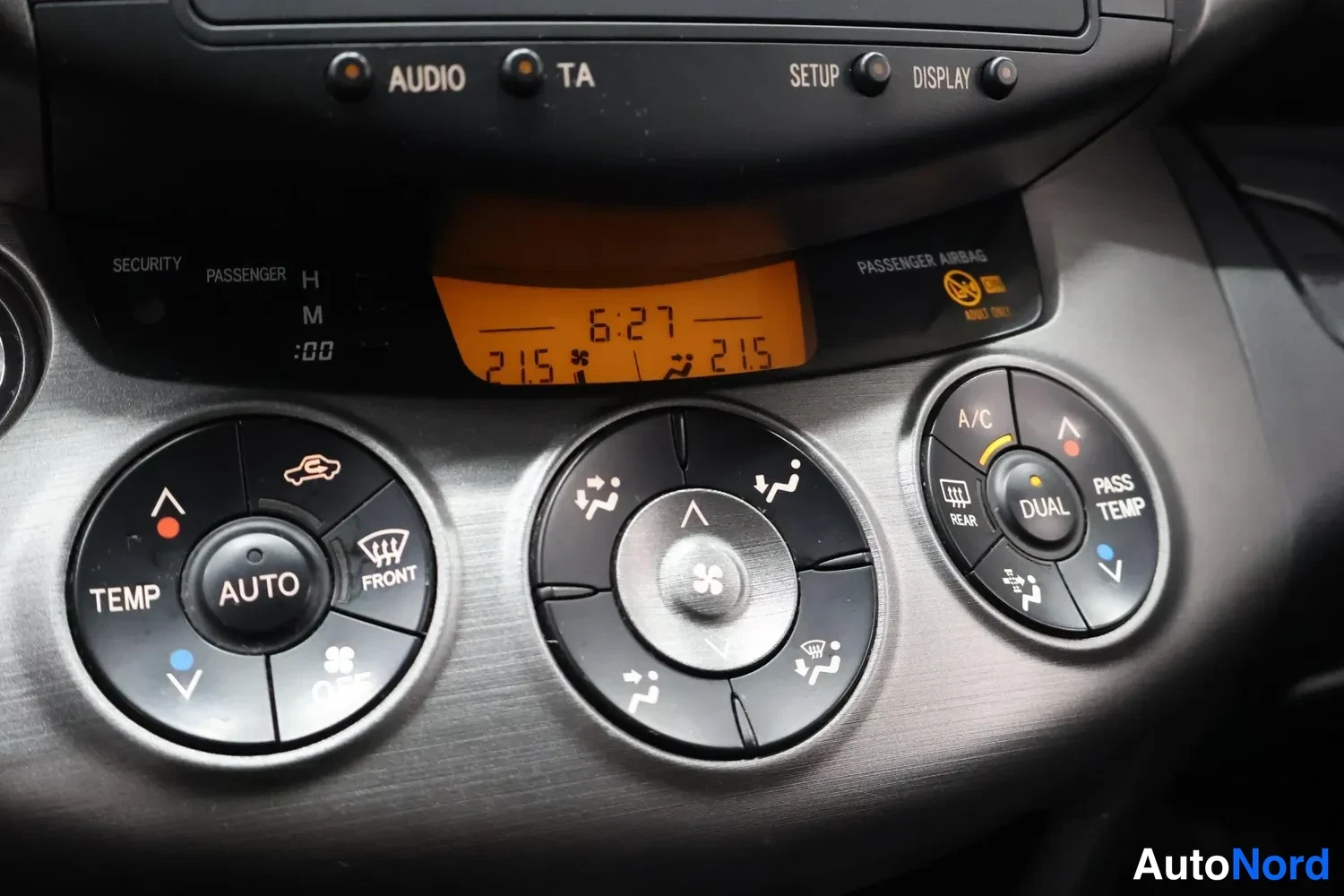 Yksityiskohta: Ulkomitta: kojelaudan automaattinen kaksivyöhykeilmastointipaneeli, jossa näkyvät TEMP, AUTO, OFF, A/C, DUAL ja PASS TEMP -säätimet, näytössä 6:27 ja 21,5 asti
