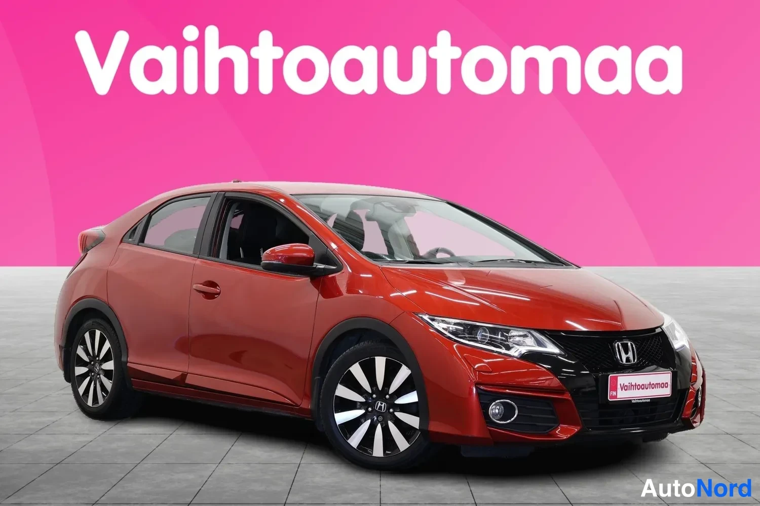 Etuviisto, nokka oikealle: Punainen Honda Civic viistosti edestä oikealta kuvattuna valohallissa.