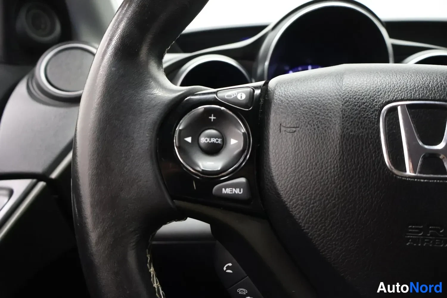 Muu: Ohjauspyörän vasemmassa puhalluksessa audio- ja puhelinpainikkeet SOURCE, MENU ja puhepainike, keskellä Honda-tunnus, takana mittaristo.