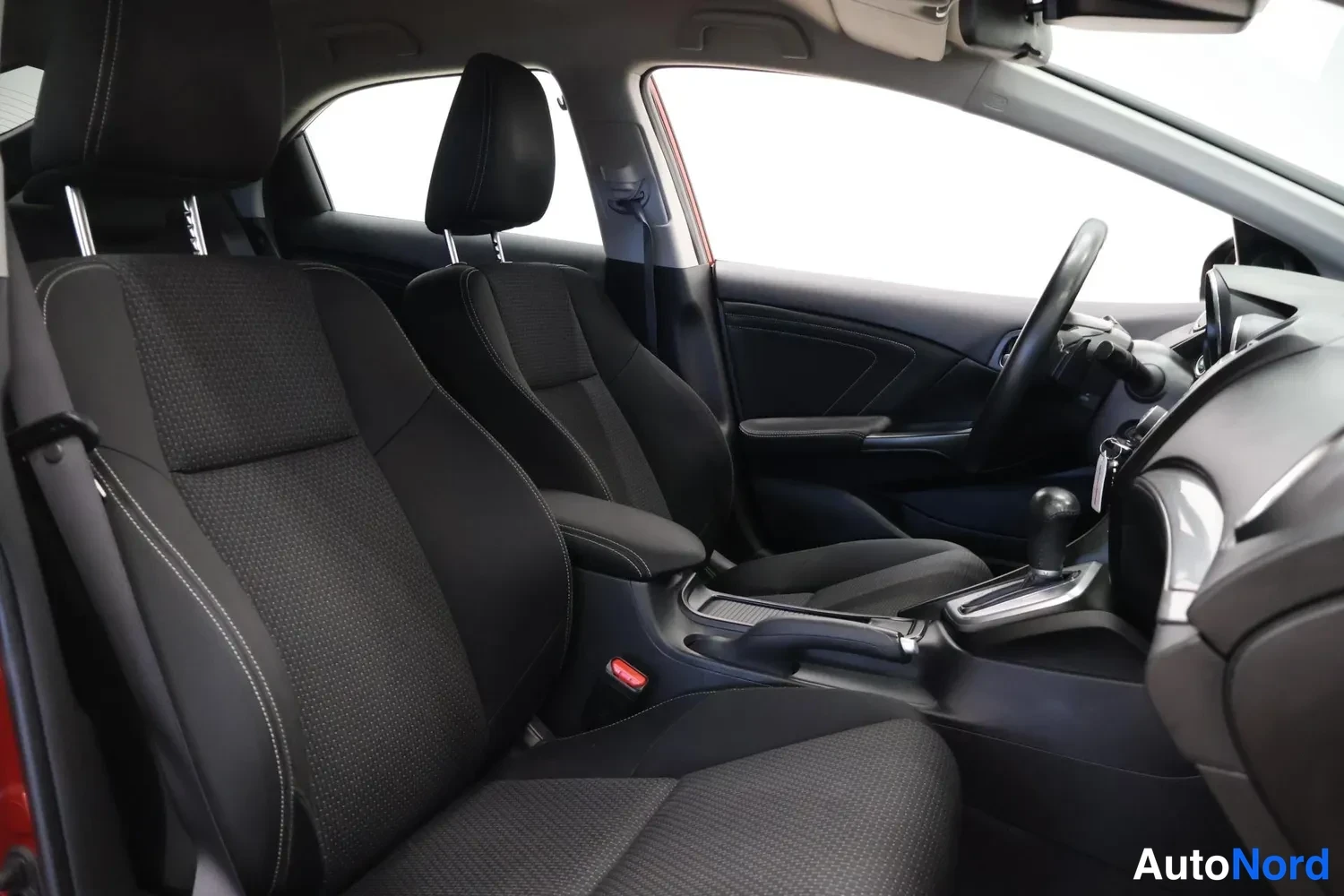 Takaviisto: Honda Civican etumatkustamo mustilla kangasistuimilla, ohjauspyörä ja vaihtajan kahva näkyvät.