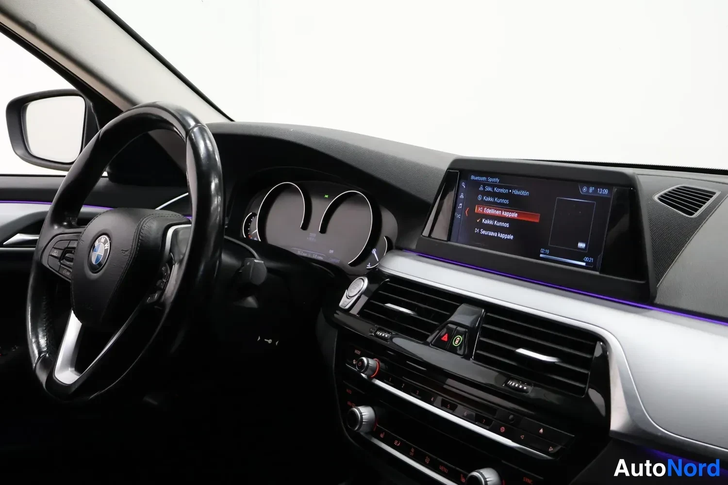 Muu: Ohjaamo vasemmalta: BMW-ohjauspyörä, mittaristo ja kojelaudan näyttö, jossa Bluetooth-puhelinvalikko.