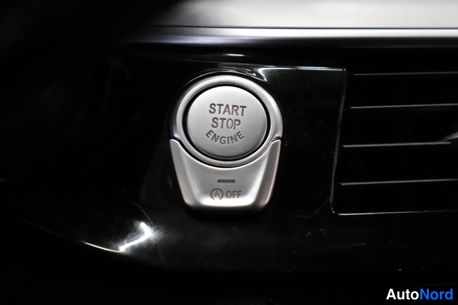 Yksityiskohta: Start Stop Engine -käynnistyspainike ja A OFF -auto-start/stop-kytkin kojelaudassa.
