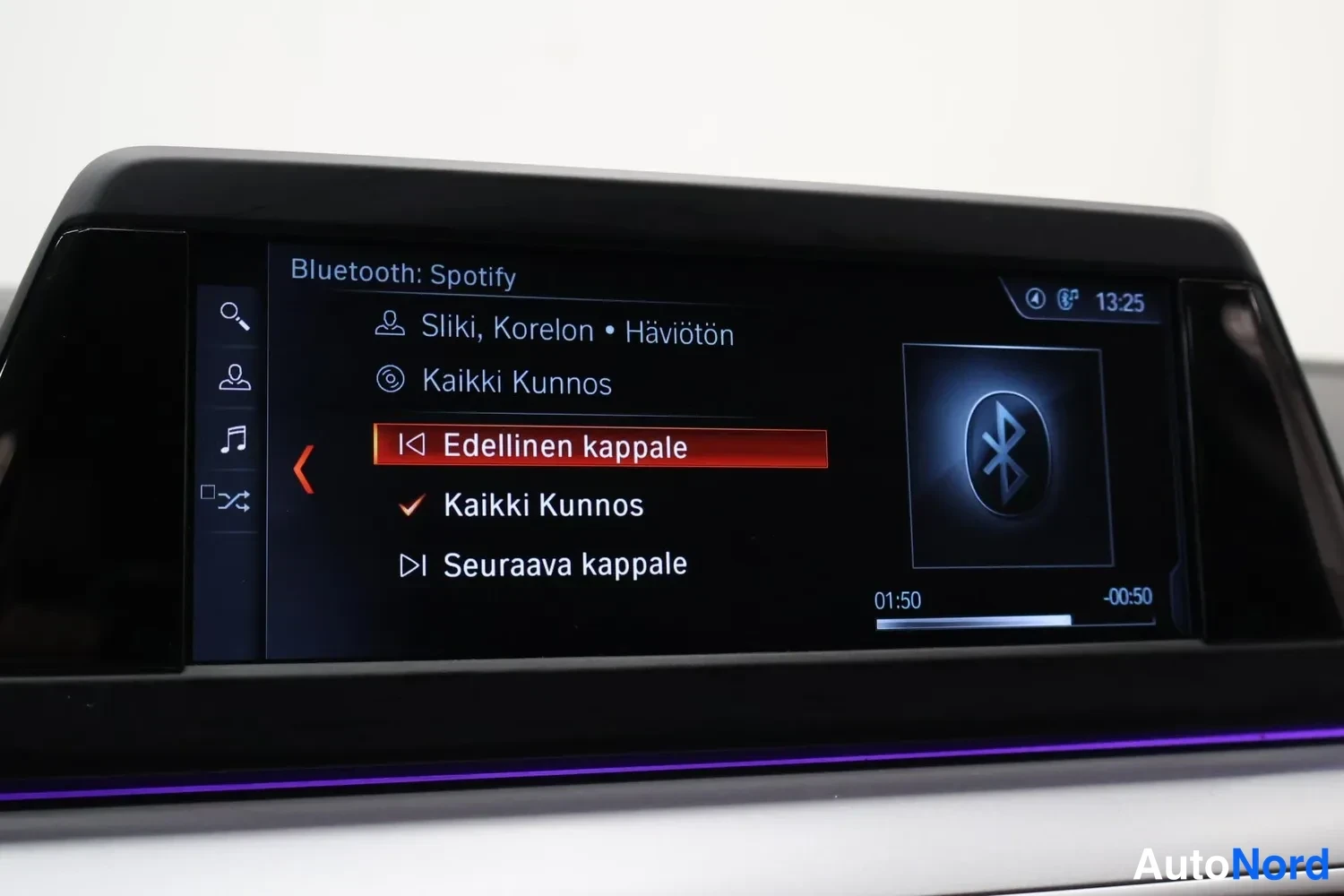 Yksityiskohta: Viihdejärjestelmän näyttö, jossa Bluetooth: Spotify -valikko ja kappalevalinnat.